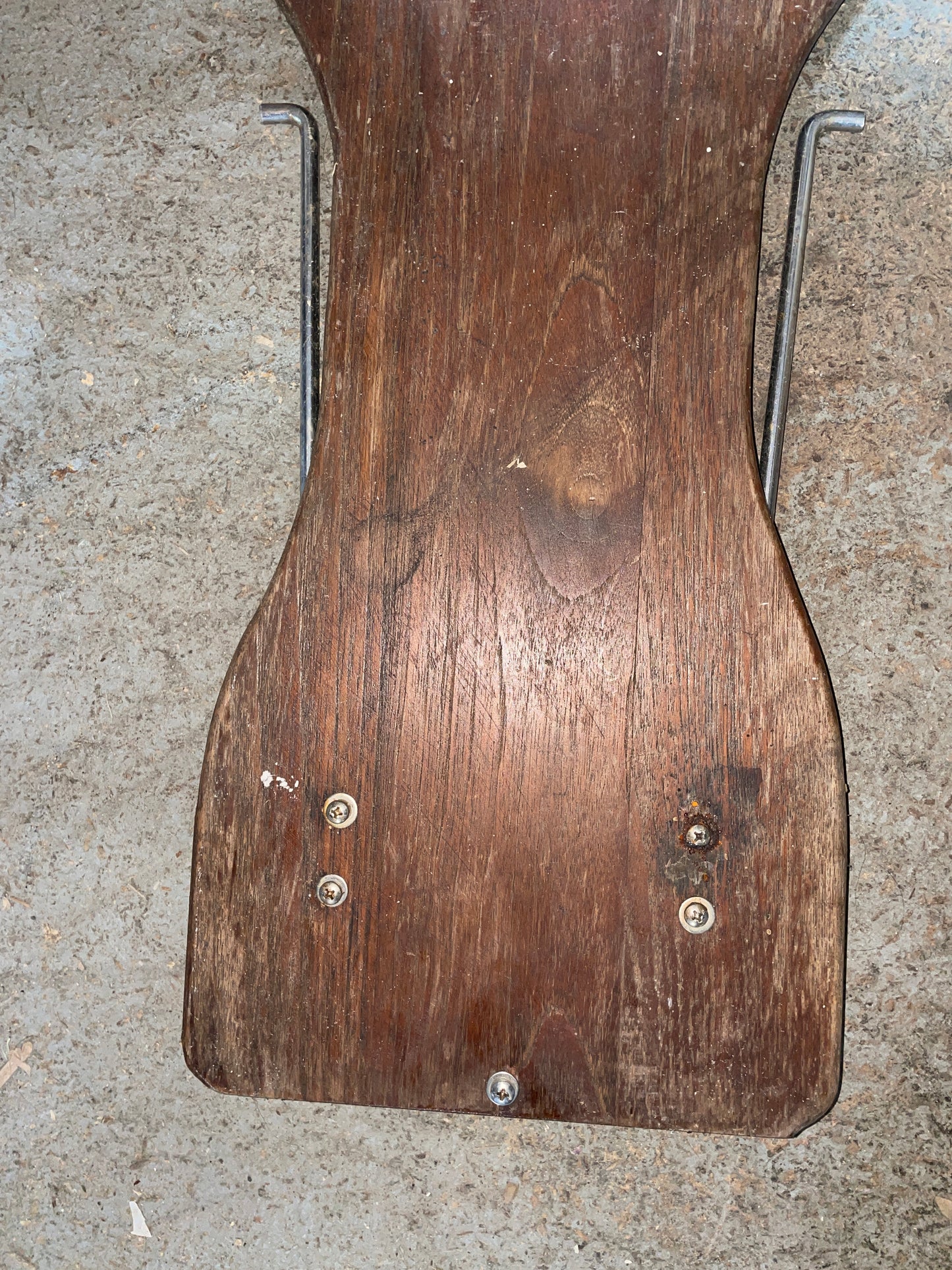 Wooden paddle with metal brackets on a concrete surface