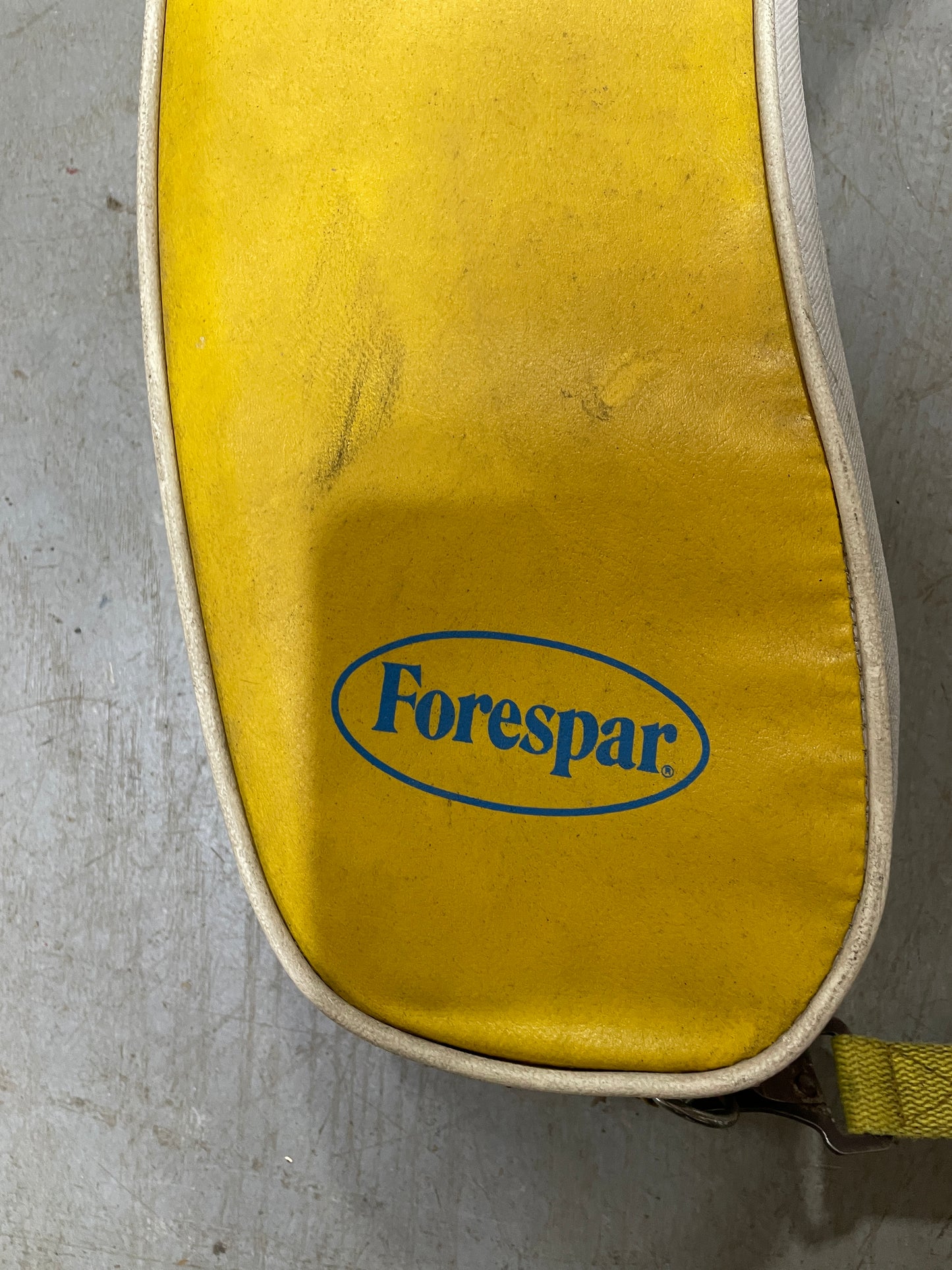 Close-up of a yellow strap with 'Forespar' logo on a gray surface