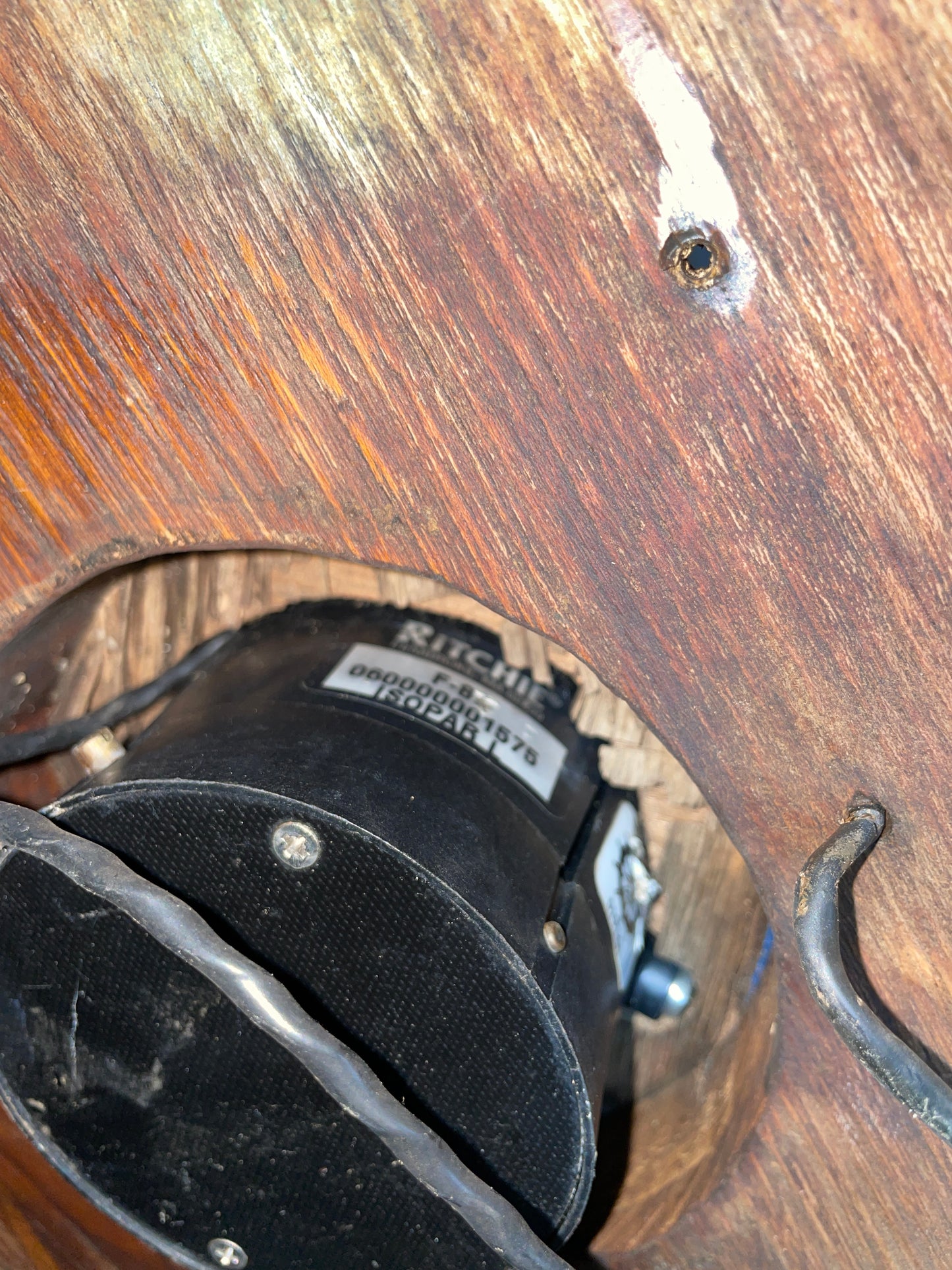 Close-up of a black mechanical component on a wooden surface