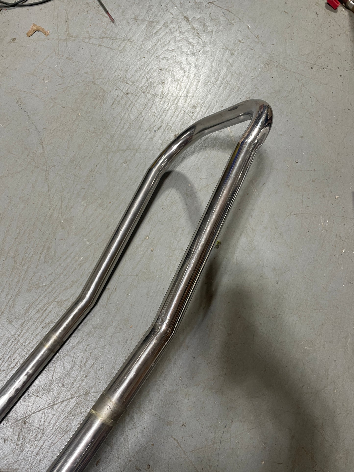 Chrome motorcycle fender on a gray surface