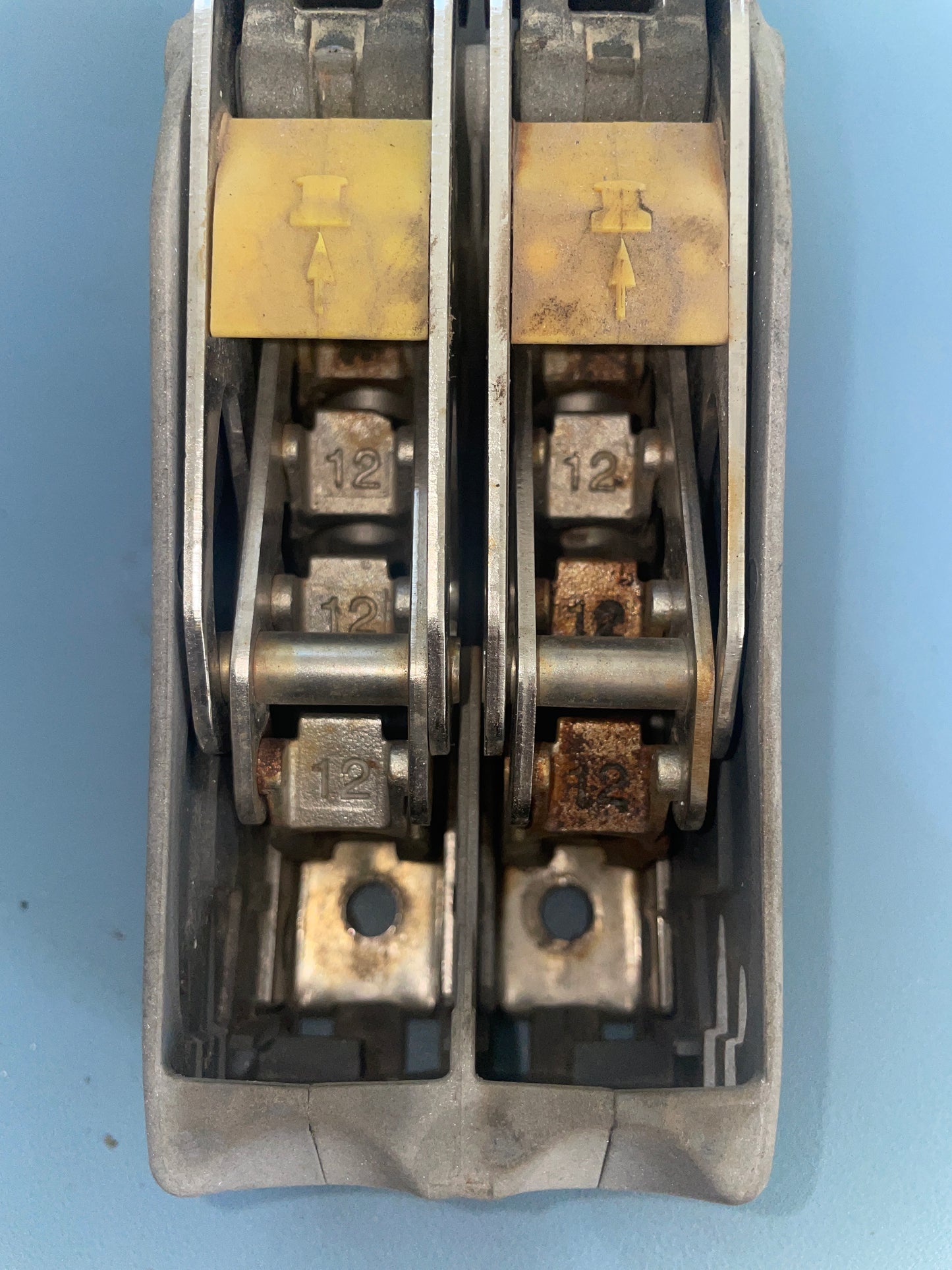 Close-up of a mechanical component with metal rollers on a blue background