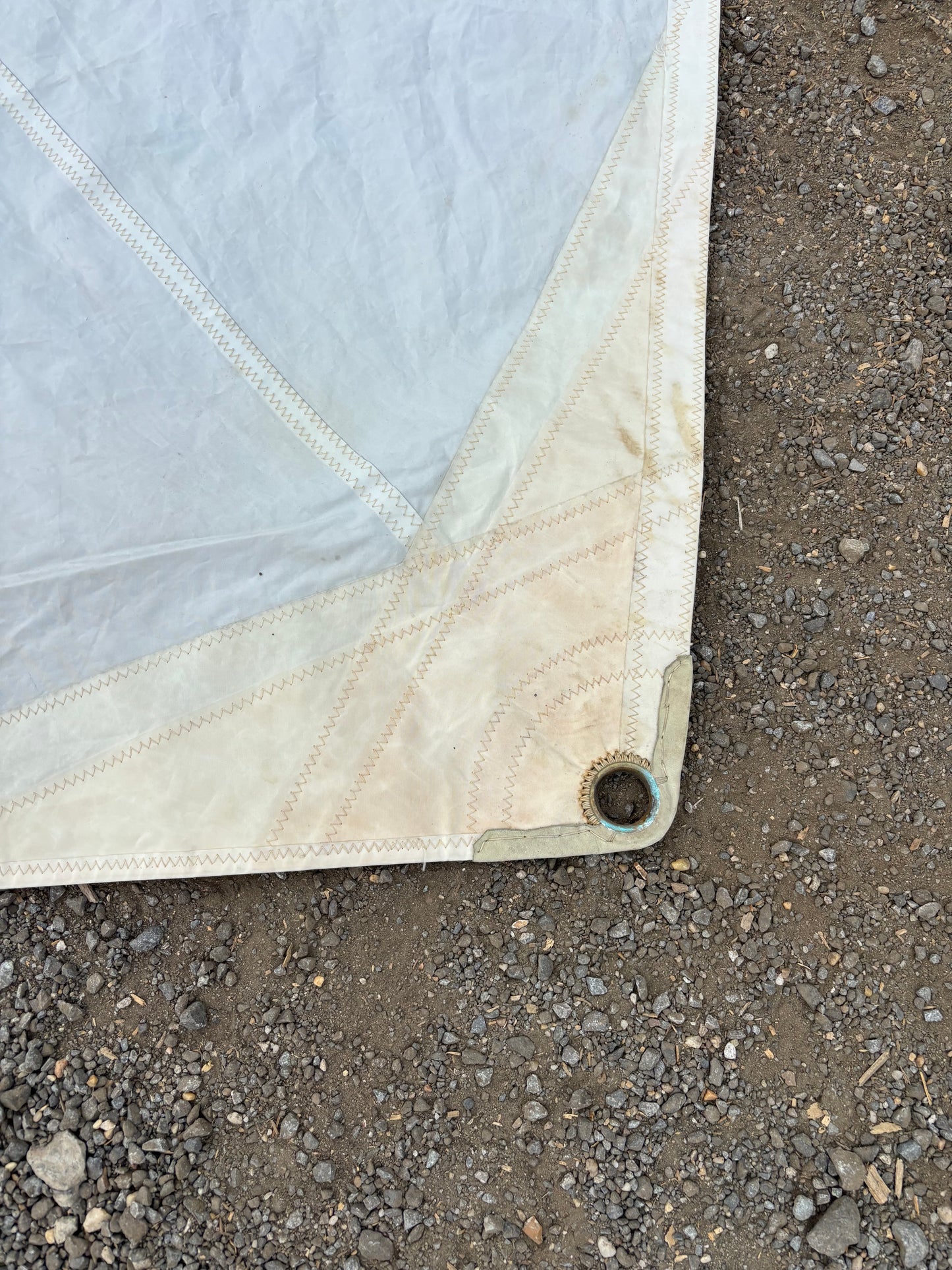 Corner of a quilted fabric on a rough asphalt surface