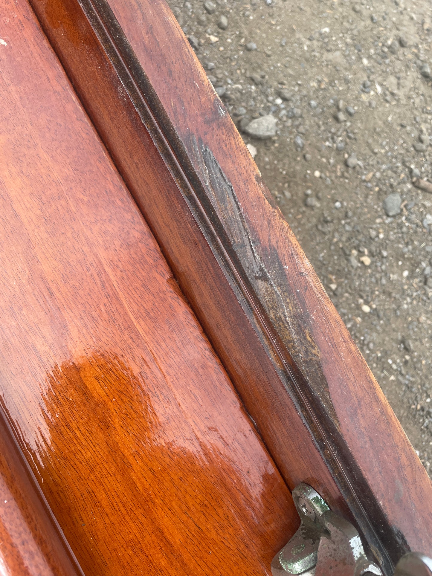 Close-up of a wooden object with metal components on a concrete surface