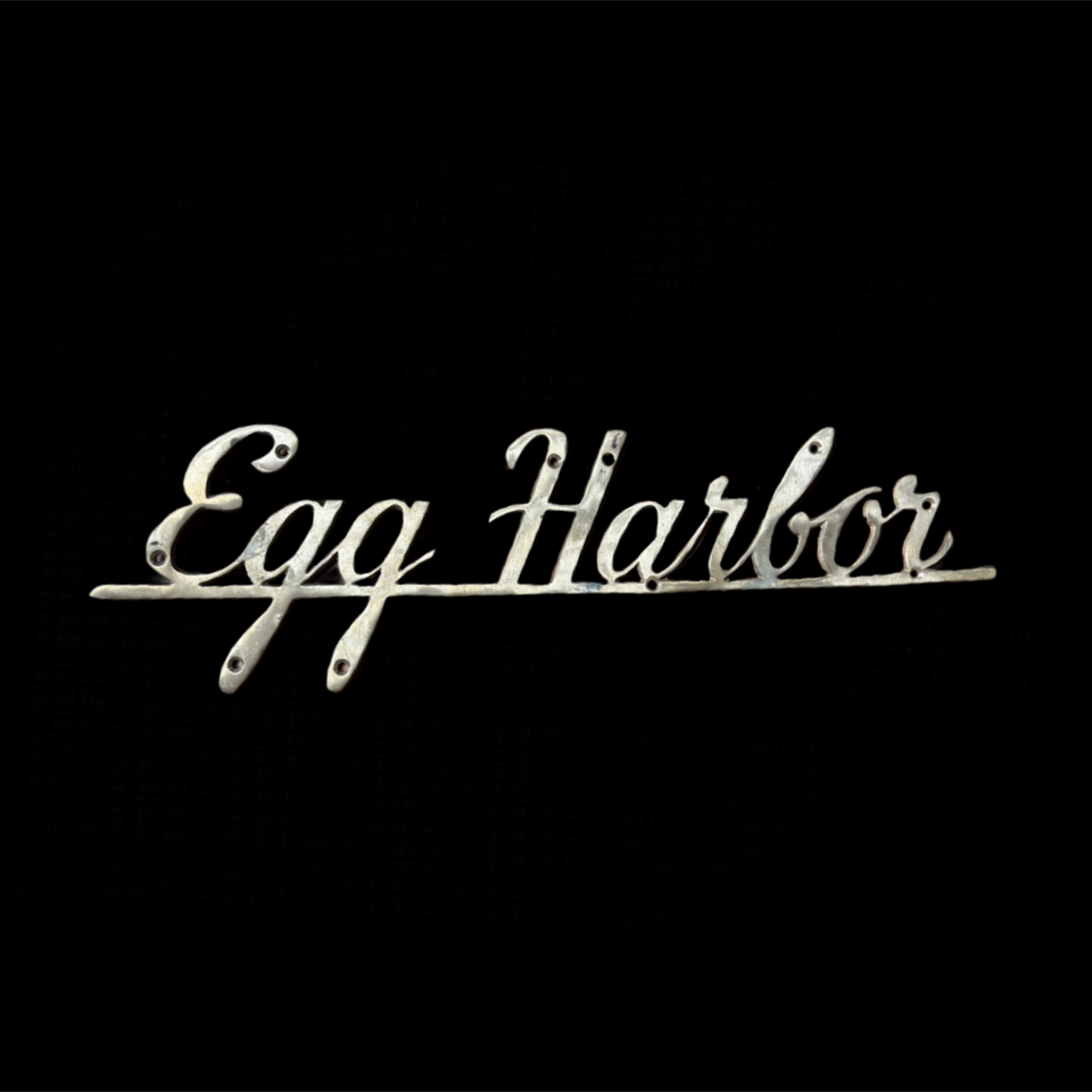 Decorative sign with 'Egg Harbor' text on a black background