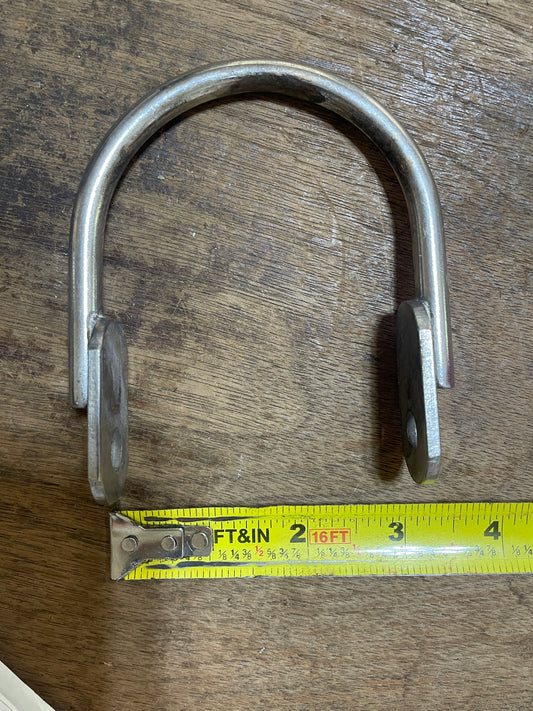 Metal U-shaped lock with a measuring tape on a wooden surface