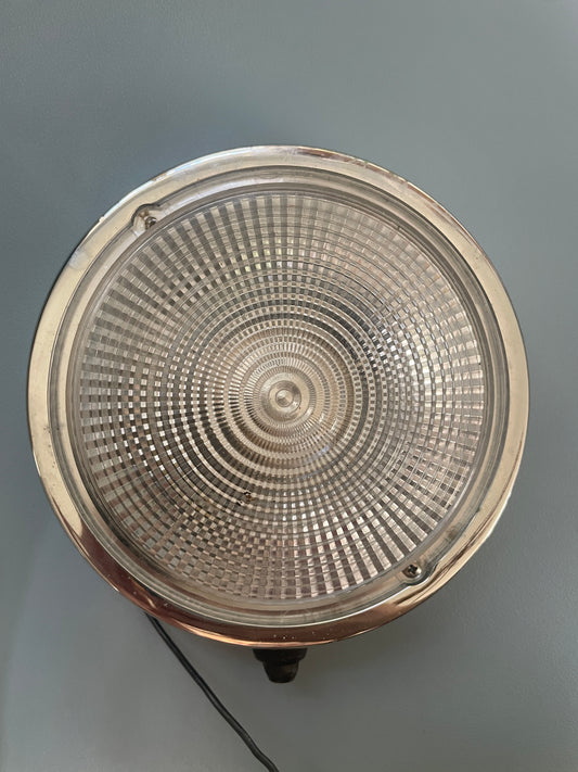 Metallic circular object with textured surface on a gray background