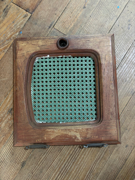 Wooden pet door with metal grille on a wooden floor