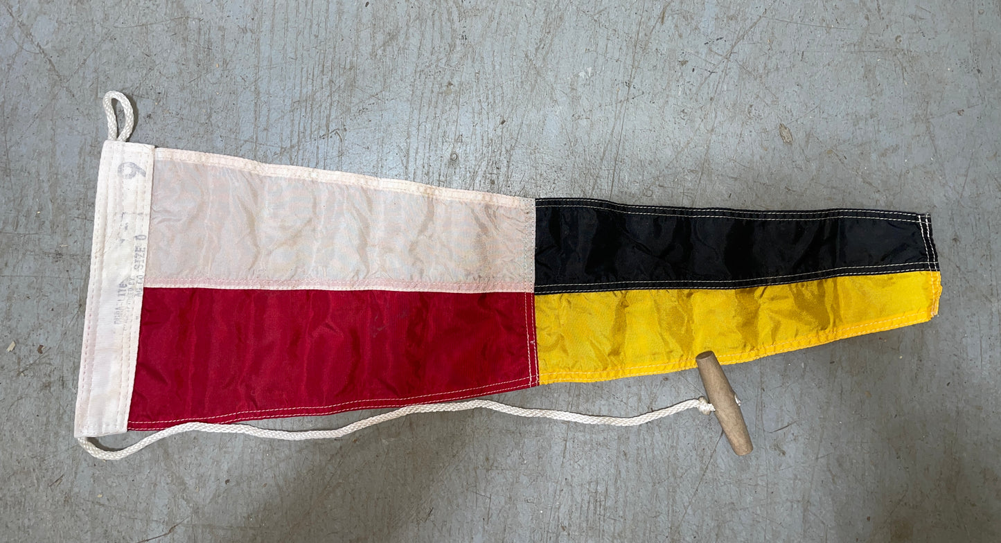 Flag with red, yellow, and black stripes on a gray surface