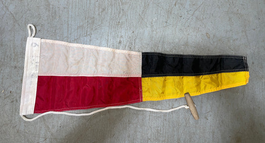 Flag with red, yellow, and black stripes on a gray surface