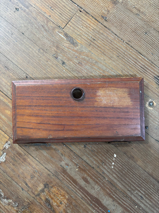 Wooden box with a circular hole on a wooden floor