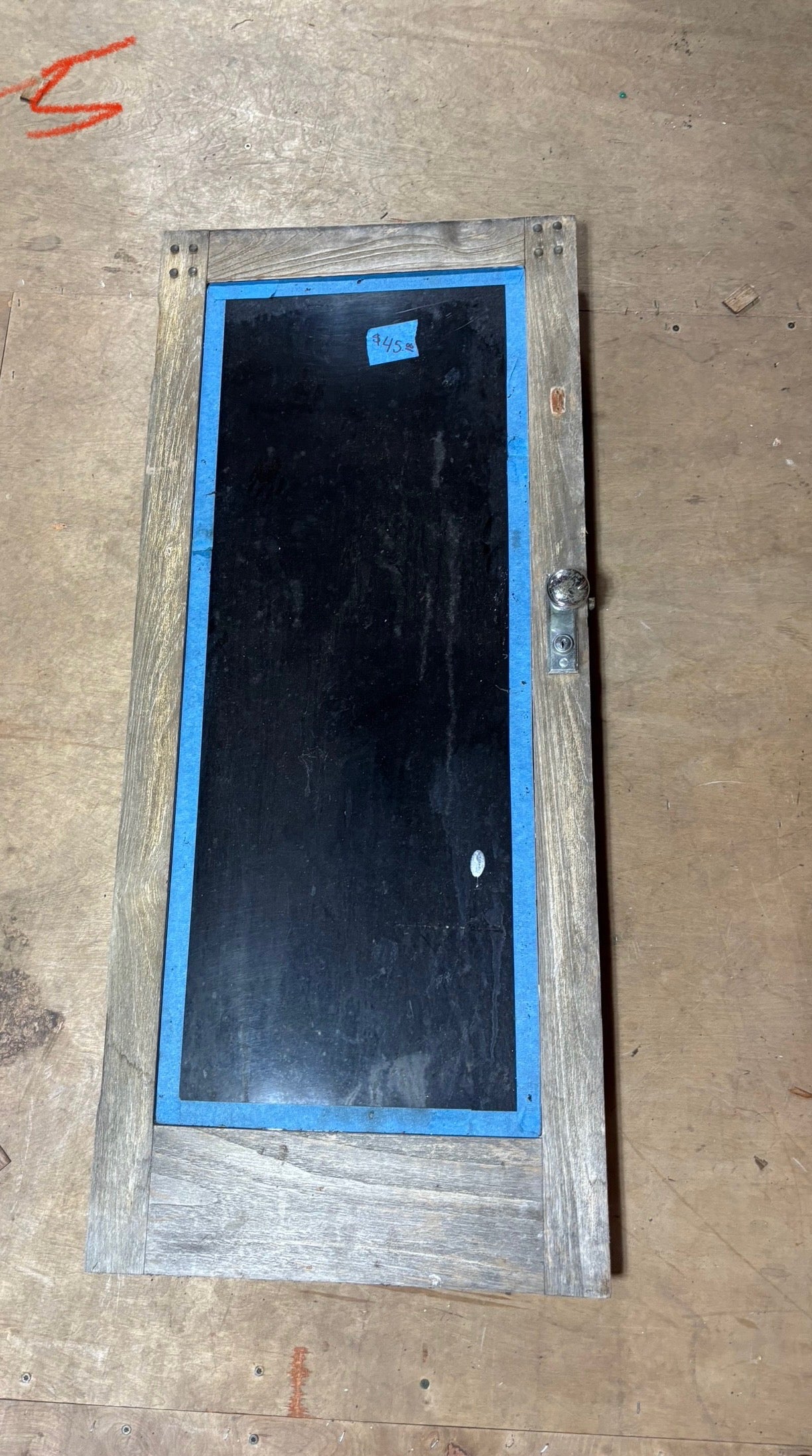 Blackboard with wooden frame and blue tape on a wooden surface