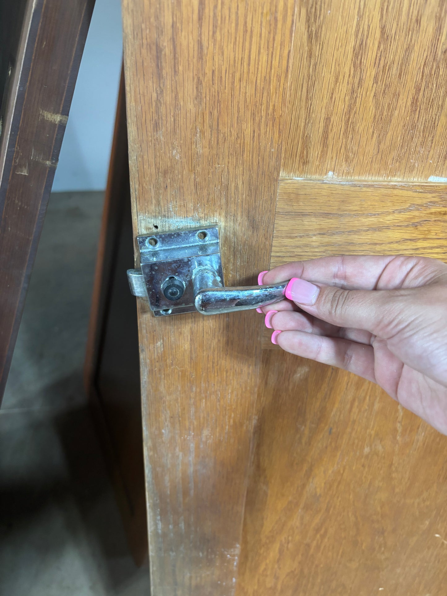 Hand holding a door handle on a wooden door