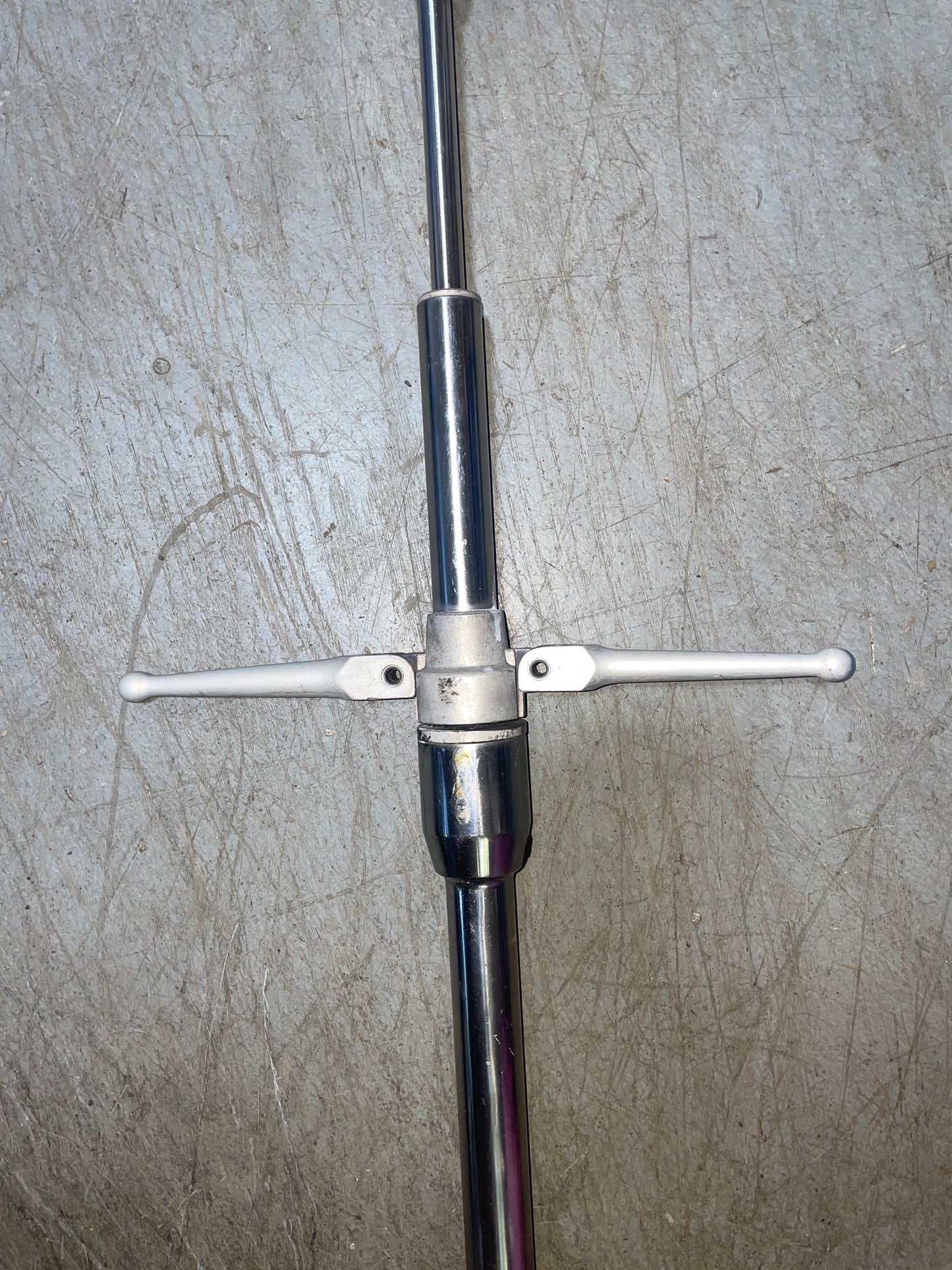 Metallic crossbar with two handles on a textured gray surface