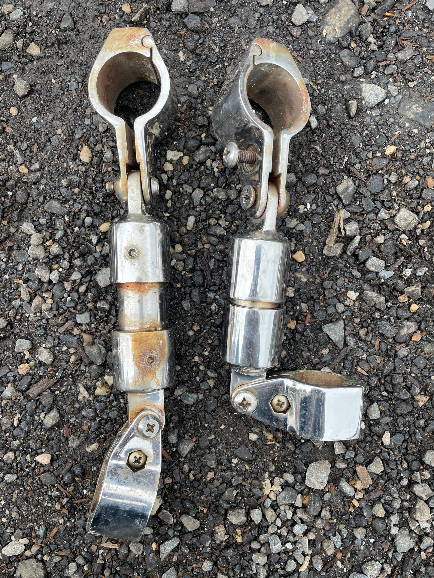 Two metal clamps on a gravel surface
