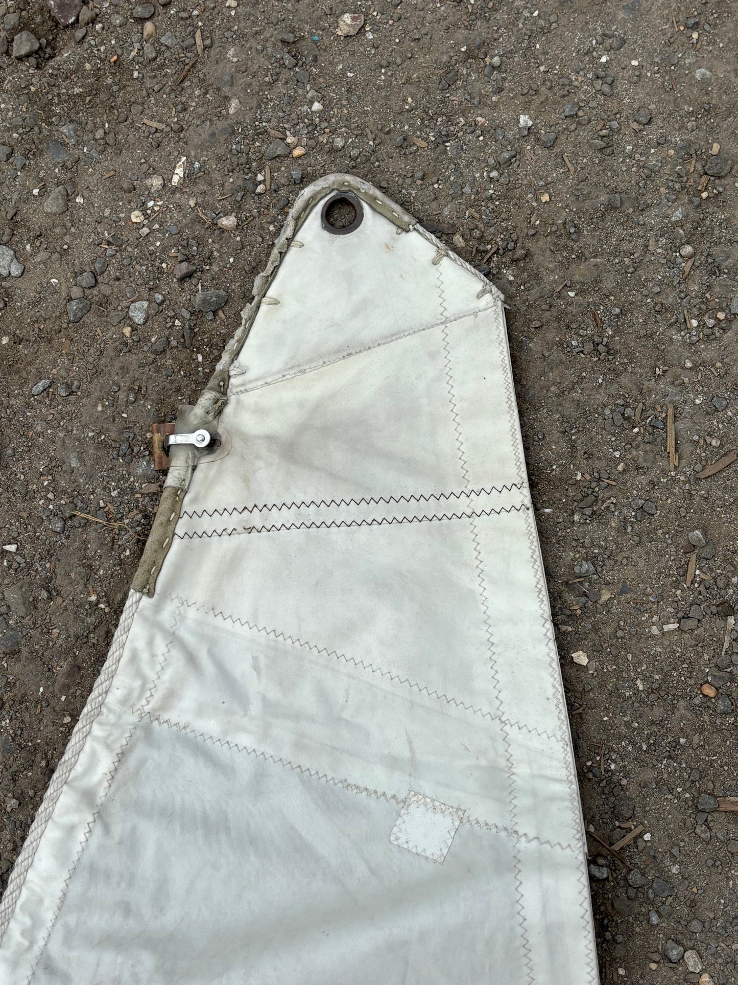White fabric with a metal grommet on a concrete surface