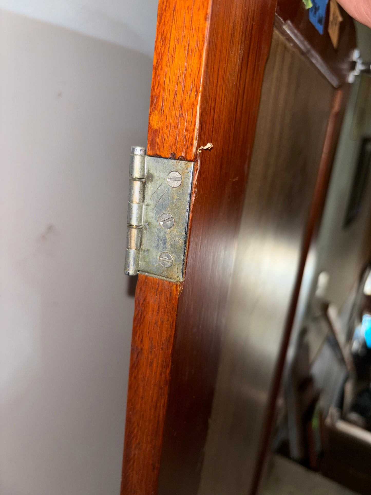Close-up of a wooden door with a metal hinge.