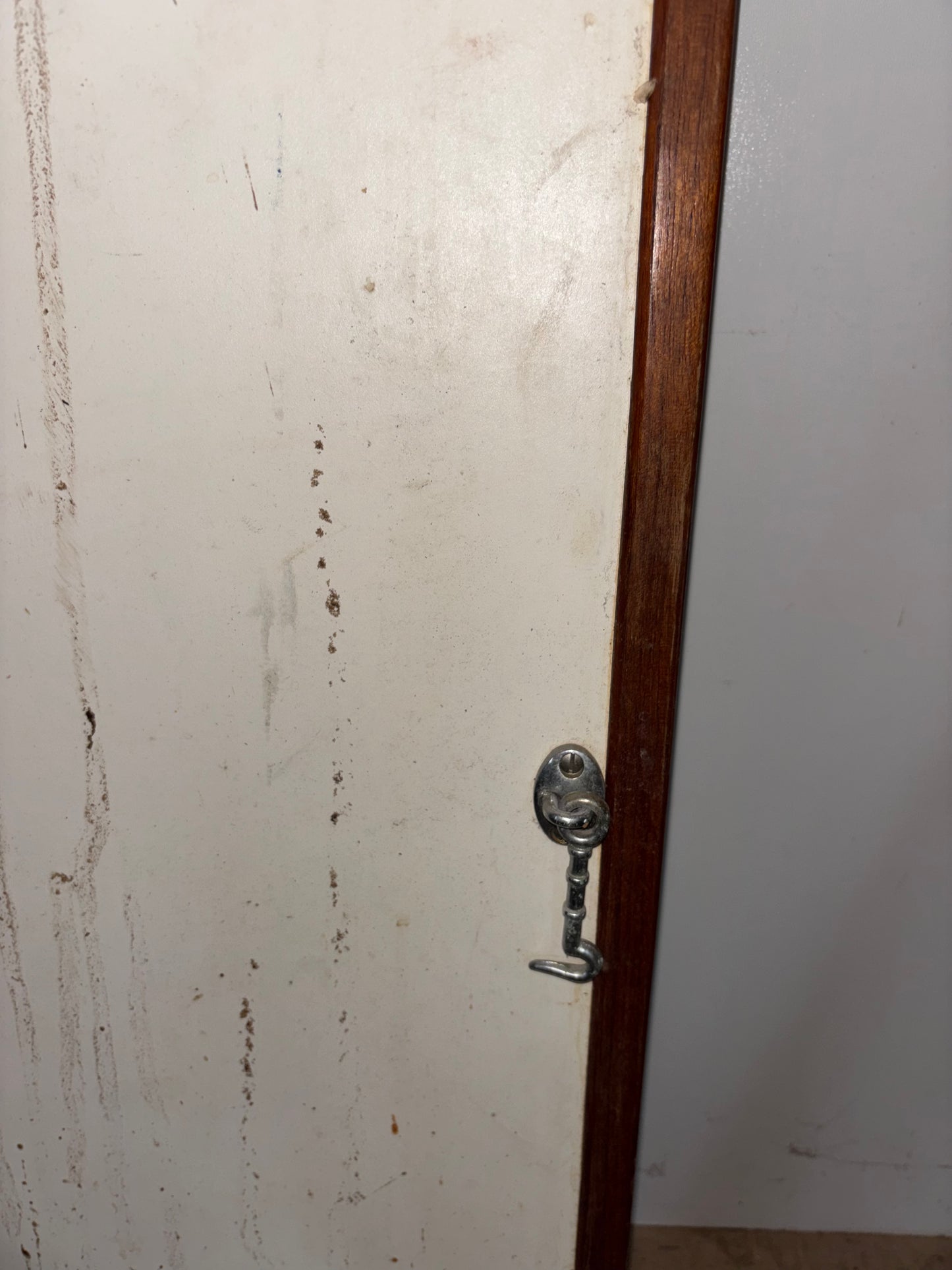 Wooden door with a metal handle on a white wall