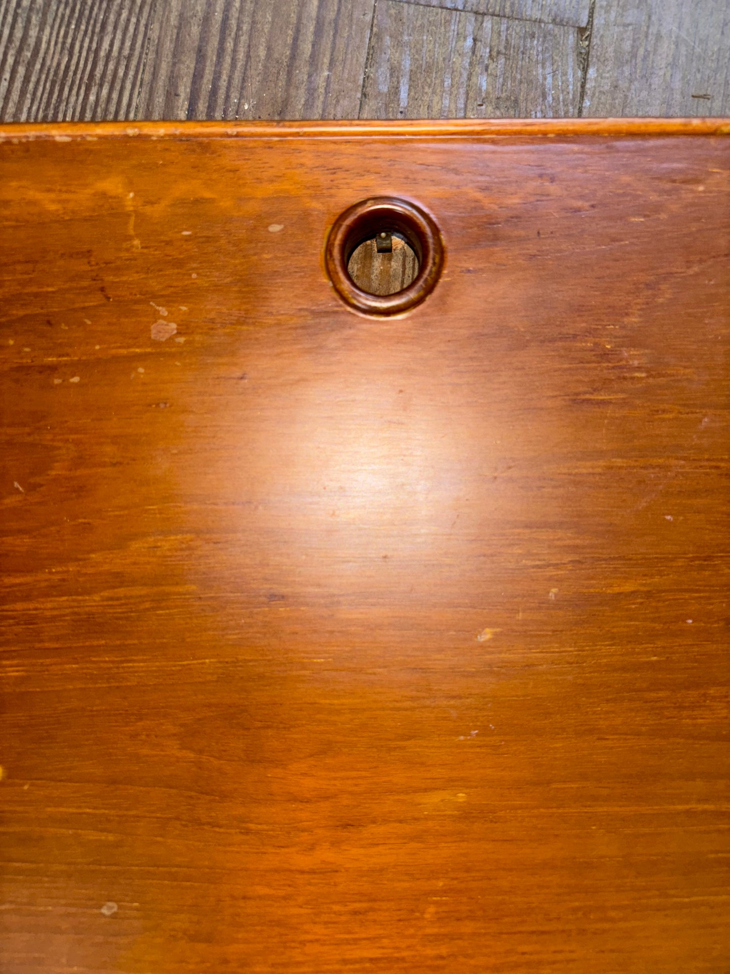 Close-up of a wooden surface with a circular hole.