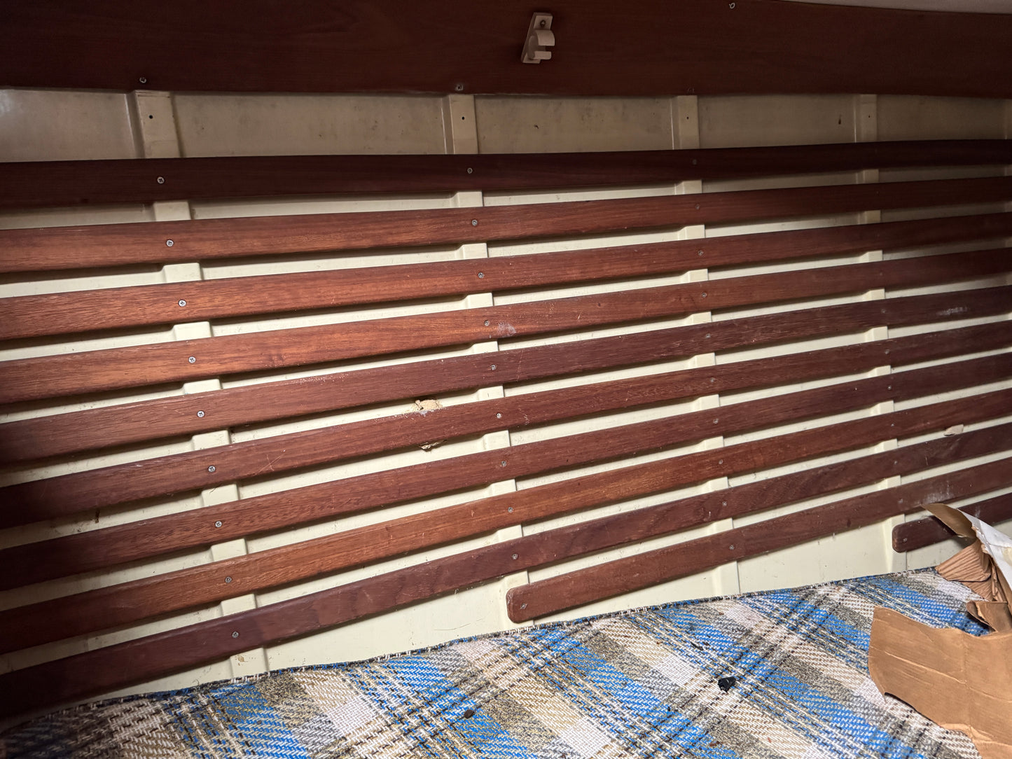 Wooden panel with metal brackets on a plaid fabric background