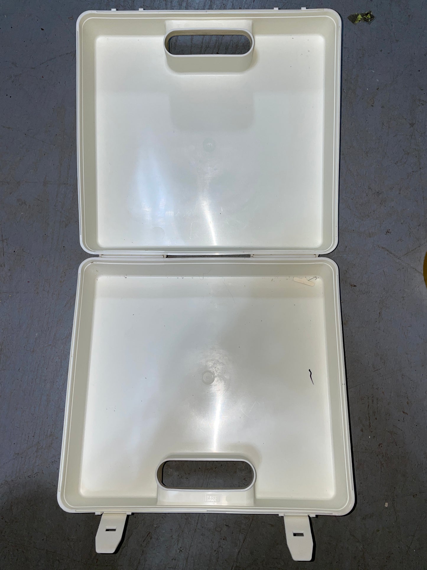 Open white plastic container on a dark surface