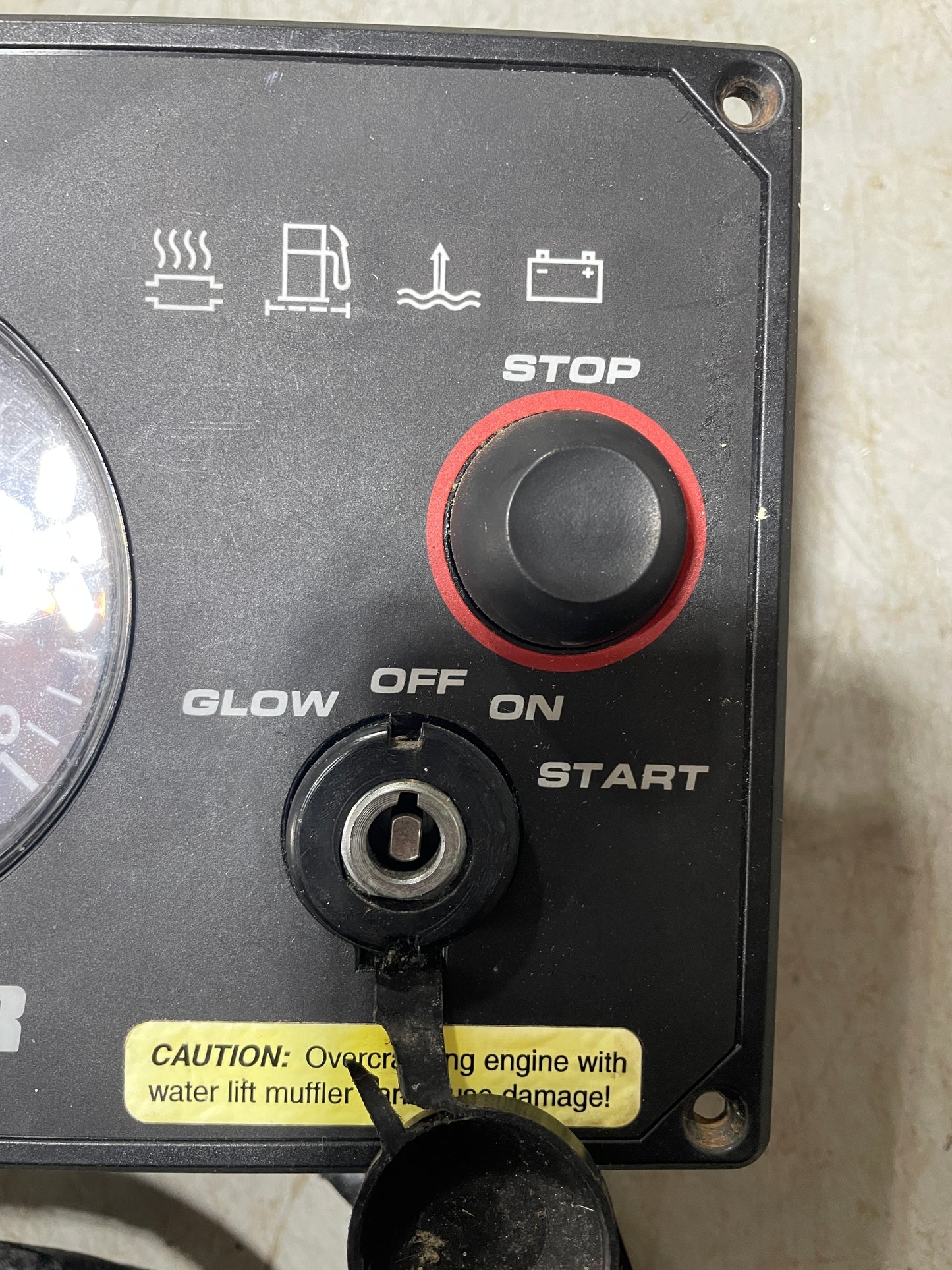 Control panel with buttons labeled 'Stop', 'Start', and 'Glow Off On' on a textured surface.