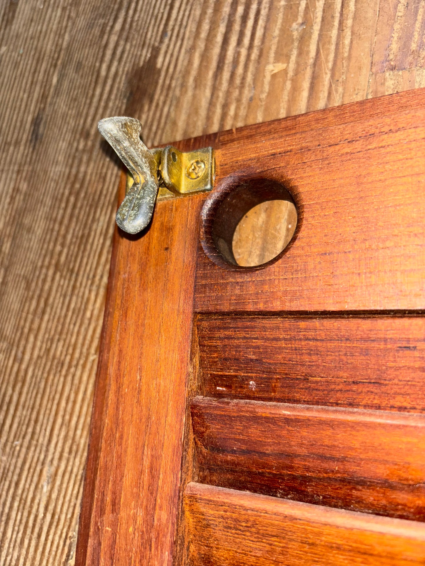 Close-up of a wooden door with a brass doorknob.