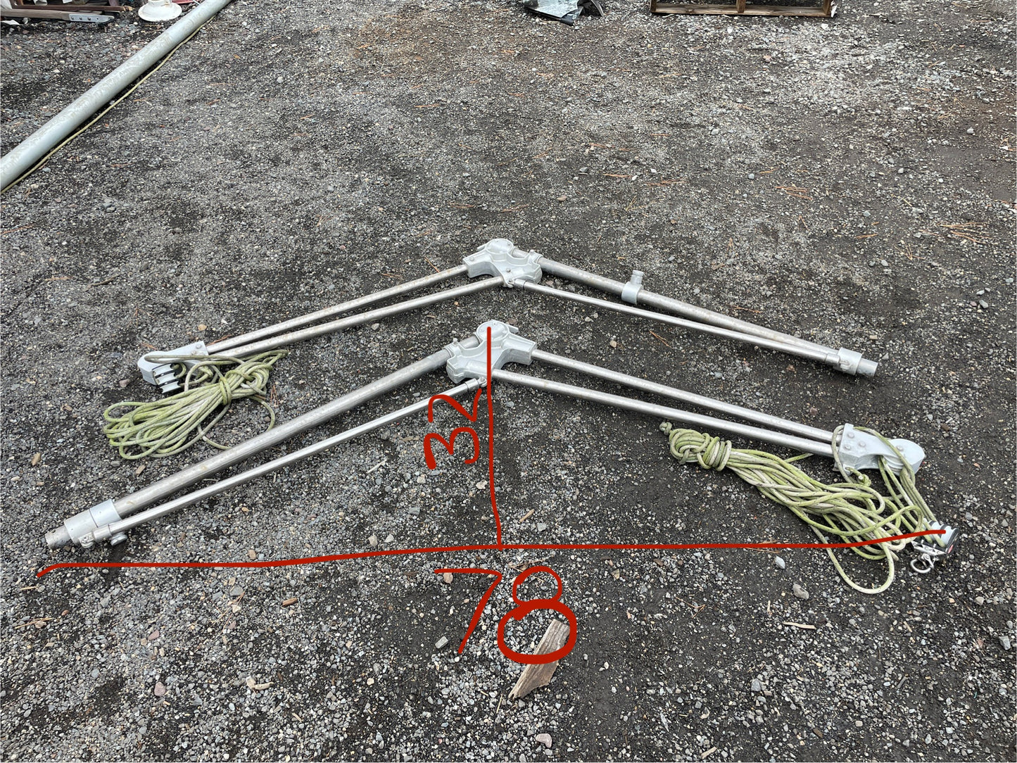 Metal frames with ropes on a concrete surface, showing measurements.