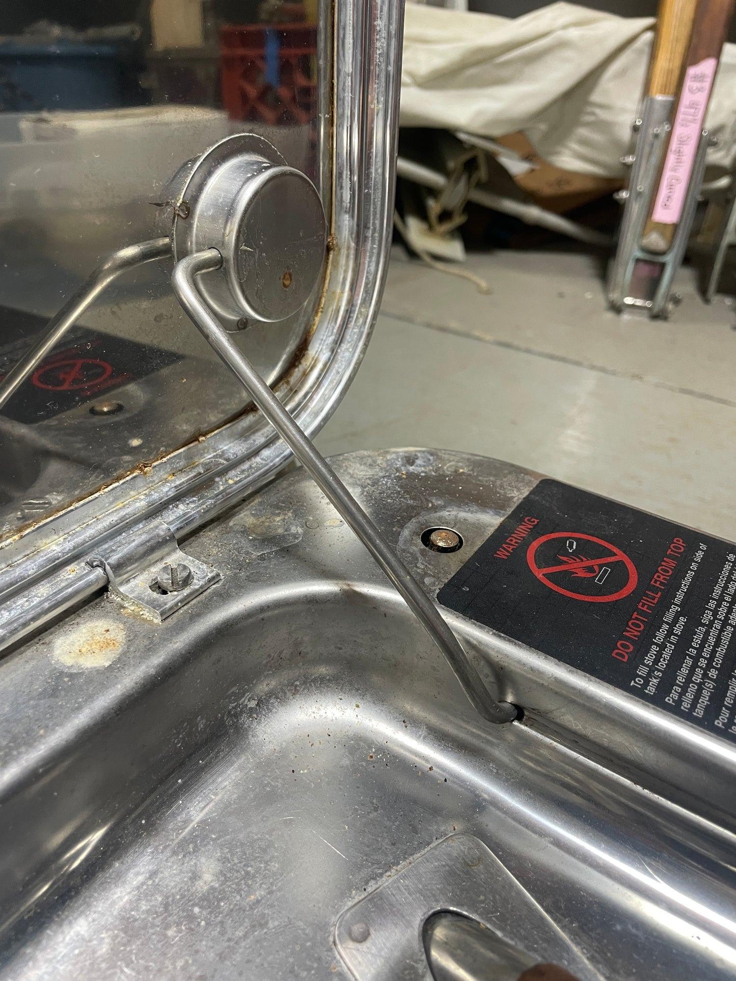Metallic door handle on a vehicle with a warning label in the background