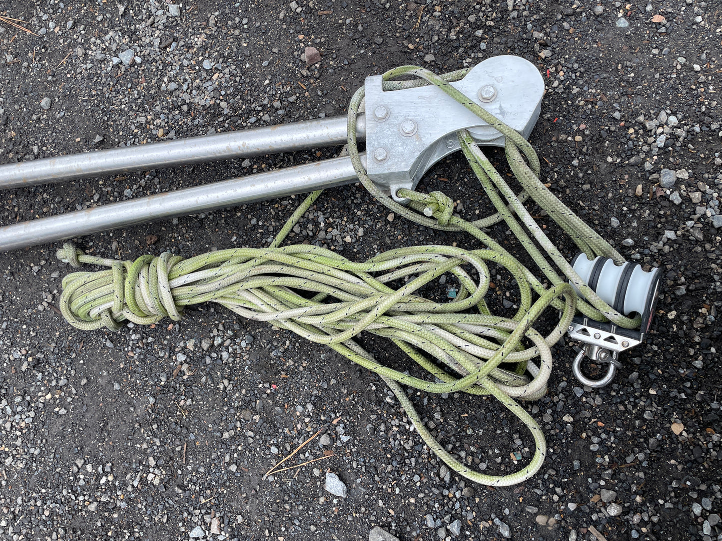 Metal tool with green rope on a concrete surface