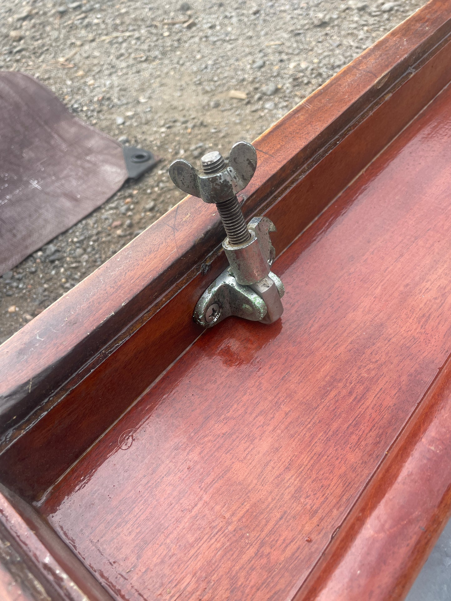 Wooden door with a metal lock mechanism on a concrete floor.