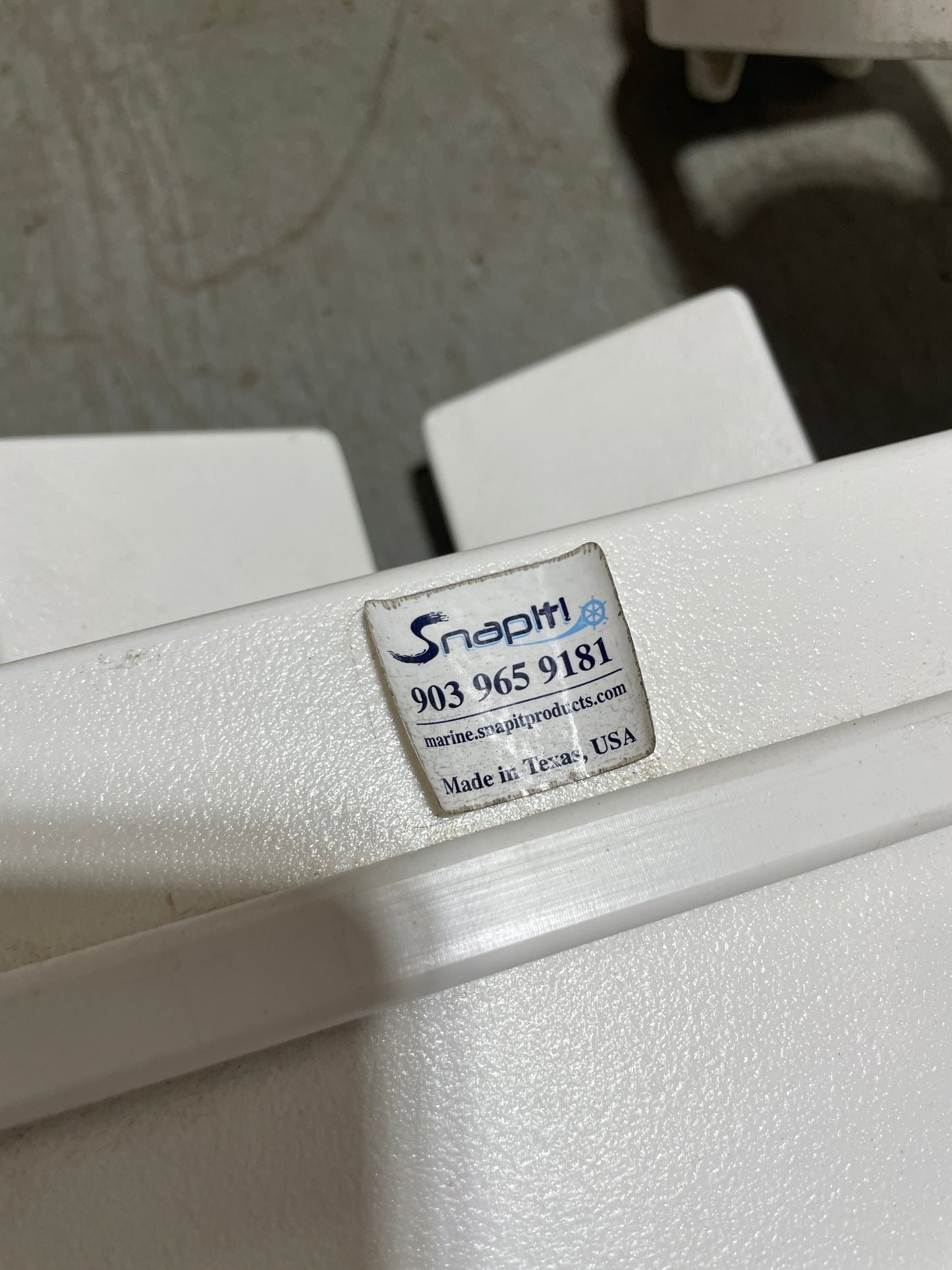 Close-up of a white appliance with a brand label on a textured surface.