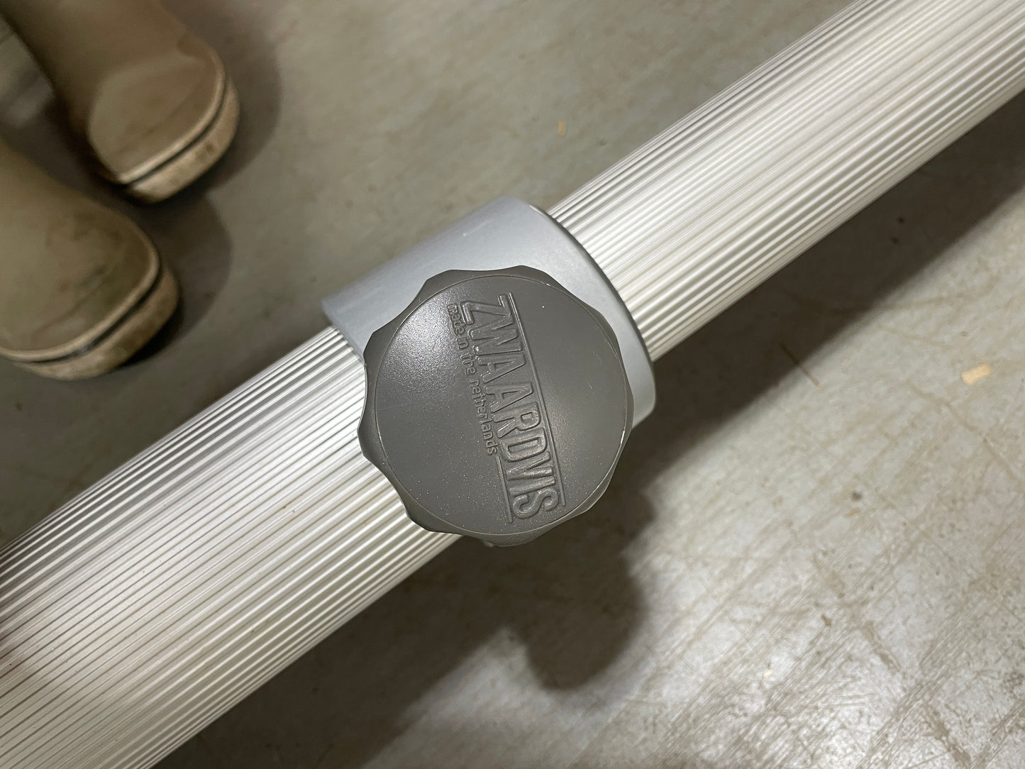 Gray clamp with 'Zeta Arrows' branding on a concrete floor.