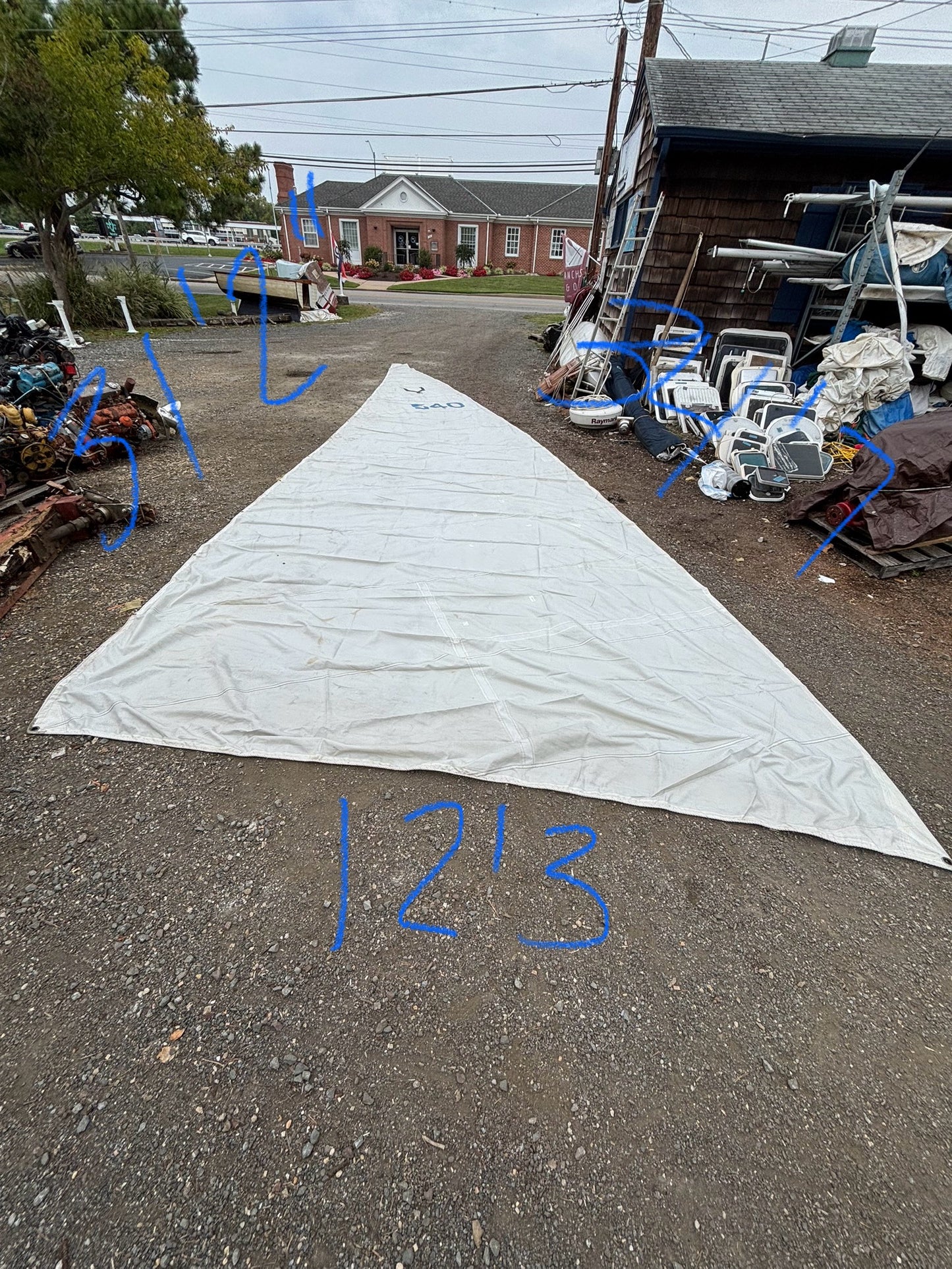 Large white sail with measurements on an outdoor lot