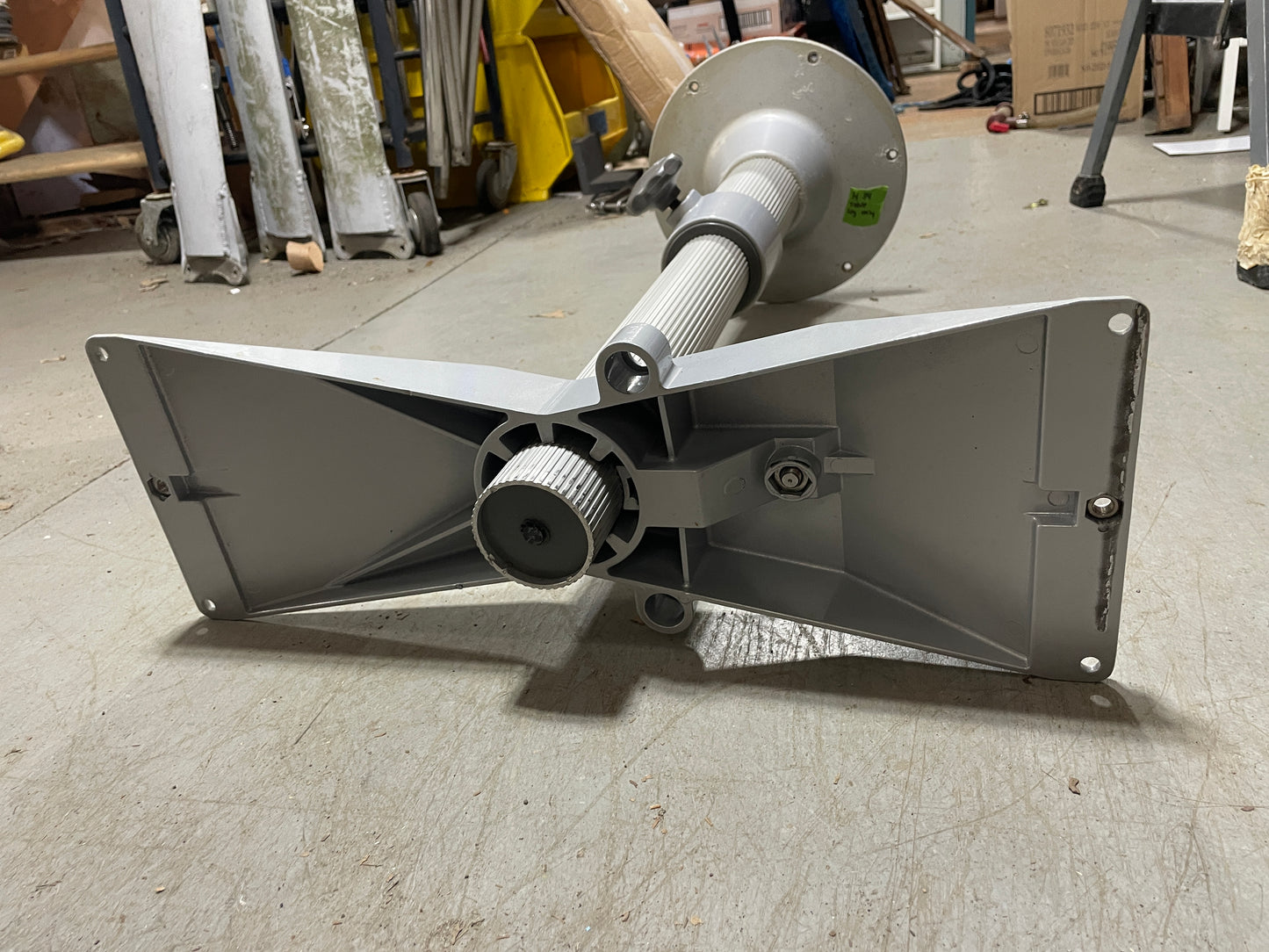 Metallic object on a concrete floor with tools and equipment in the background