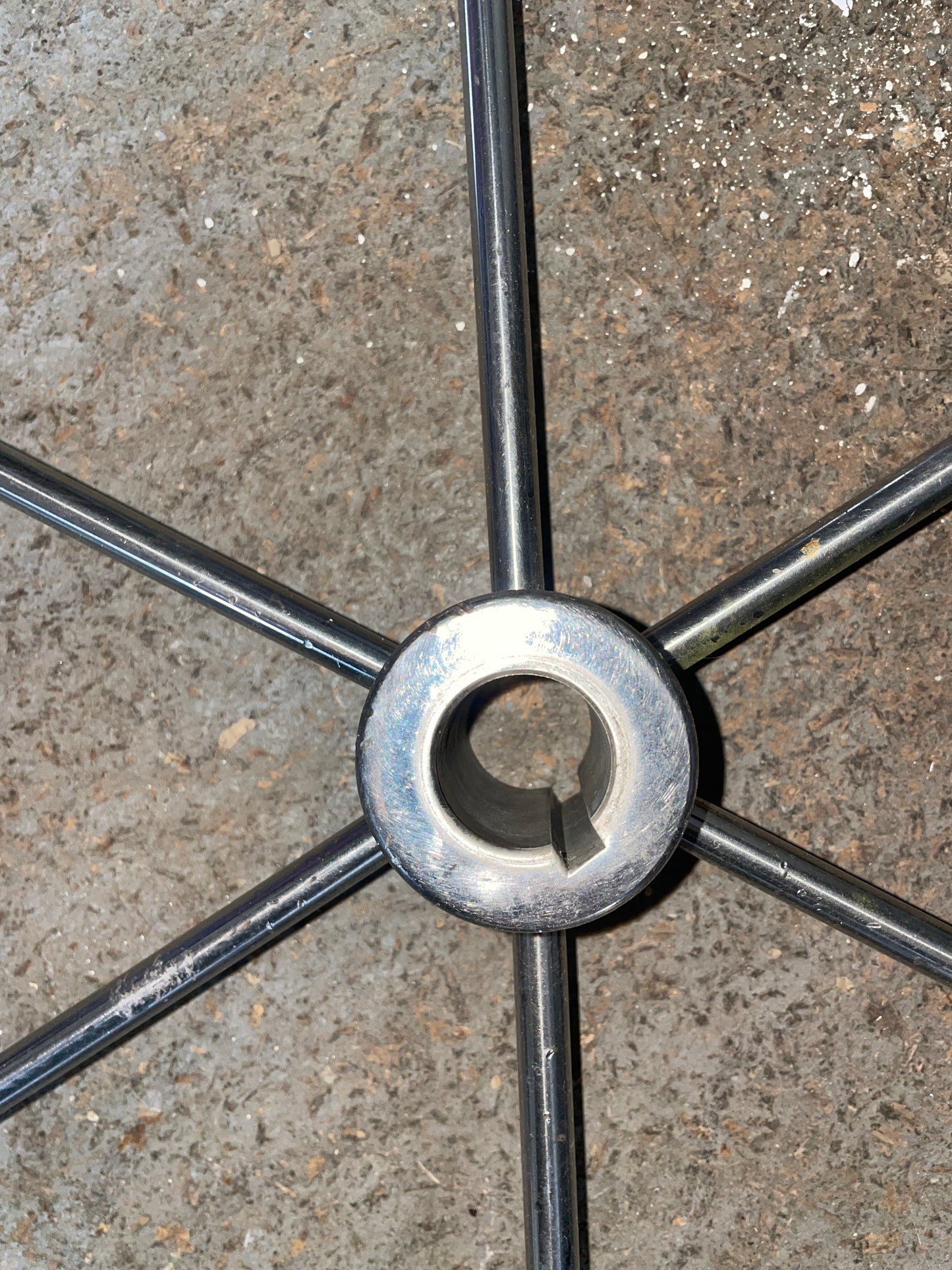 Metal stand base with five arms on a concrete surface