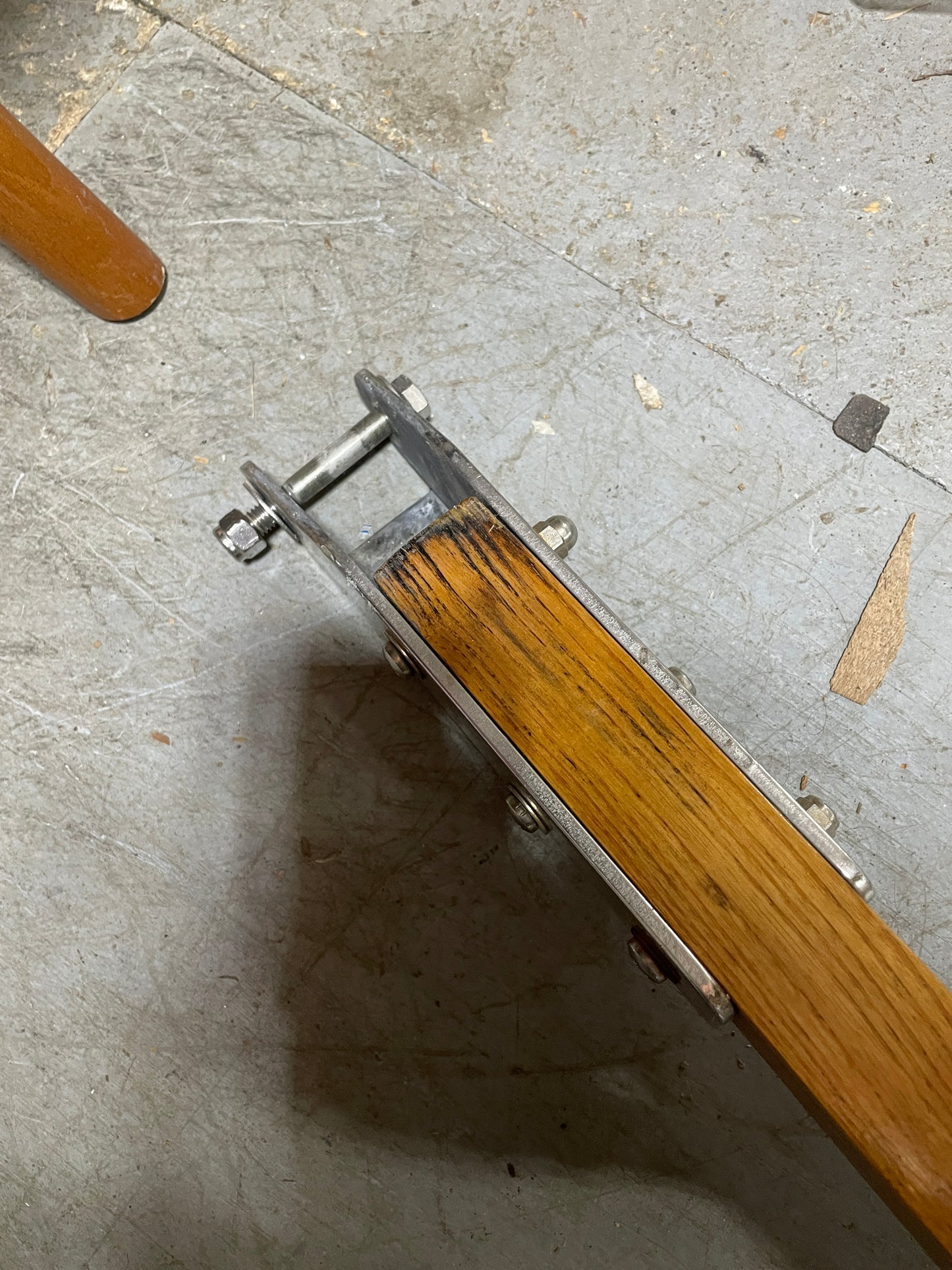 Wooden floor edge trim with metal fitting on a concrete floor