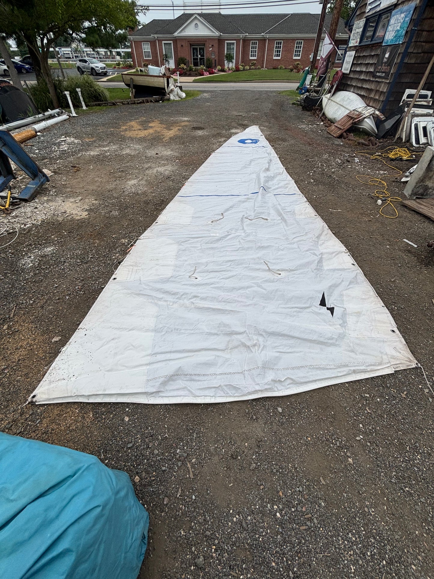Large white sail on a driveway with a house in the background