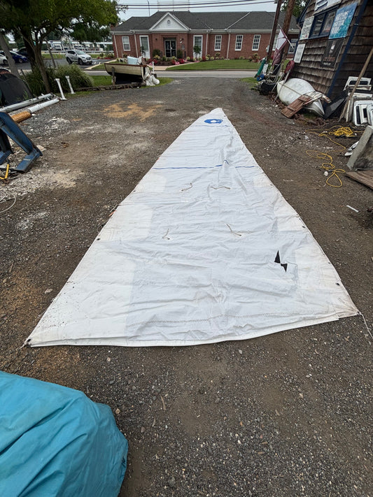 Large white sail on a driveway with a house in the background