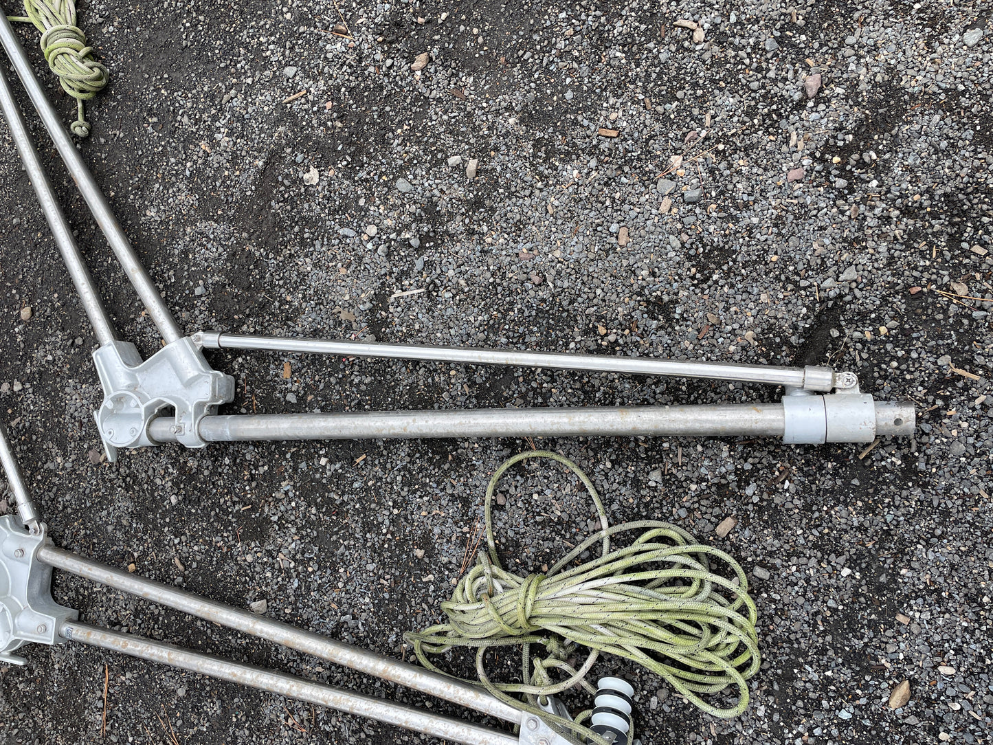 Metal tripod legs with ropes on a concrete surface
