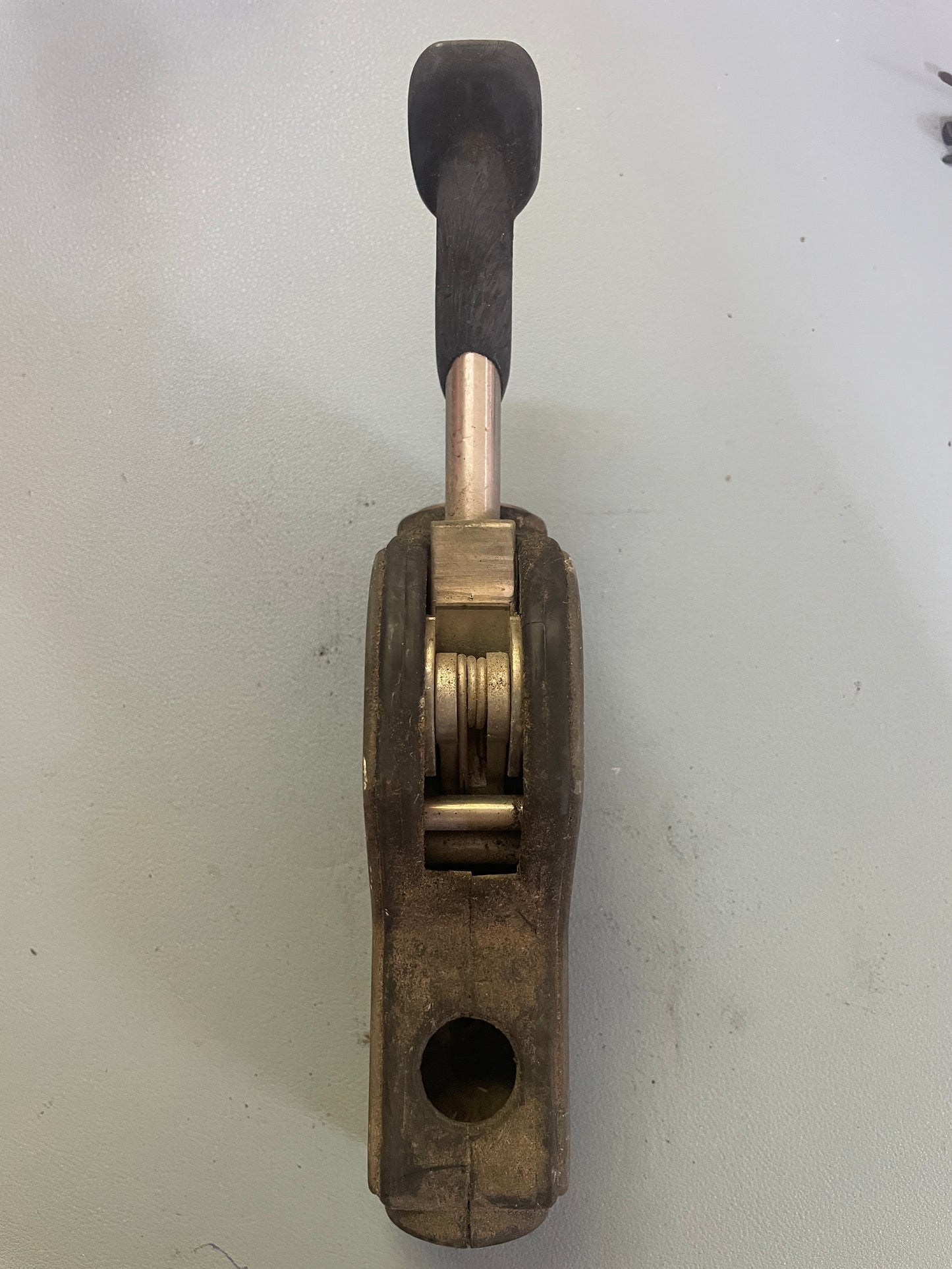 Vintage-style tool with wooden handle and metal components on a white background