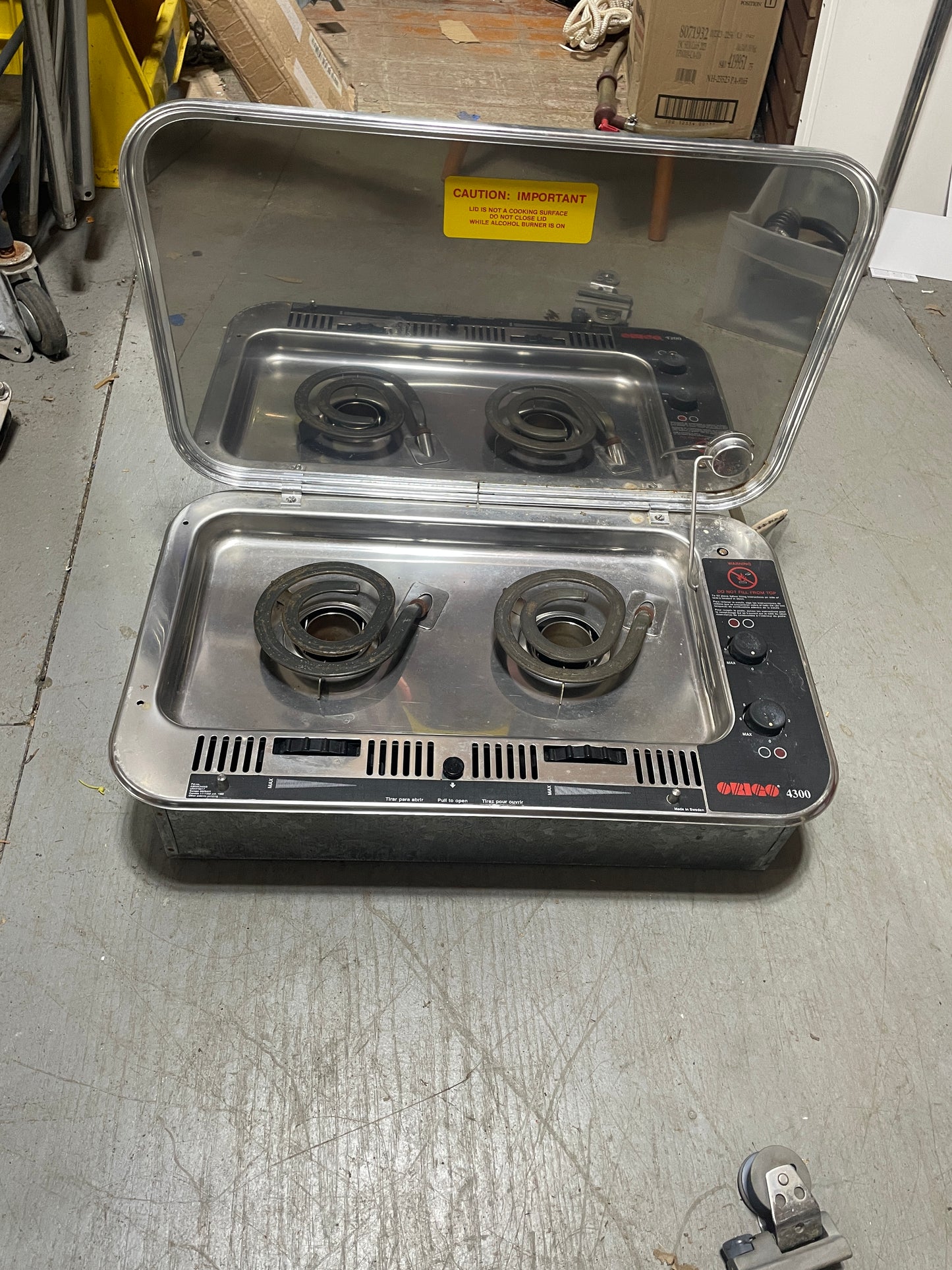 Stainless steel cooktop with four burners on a metal surface