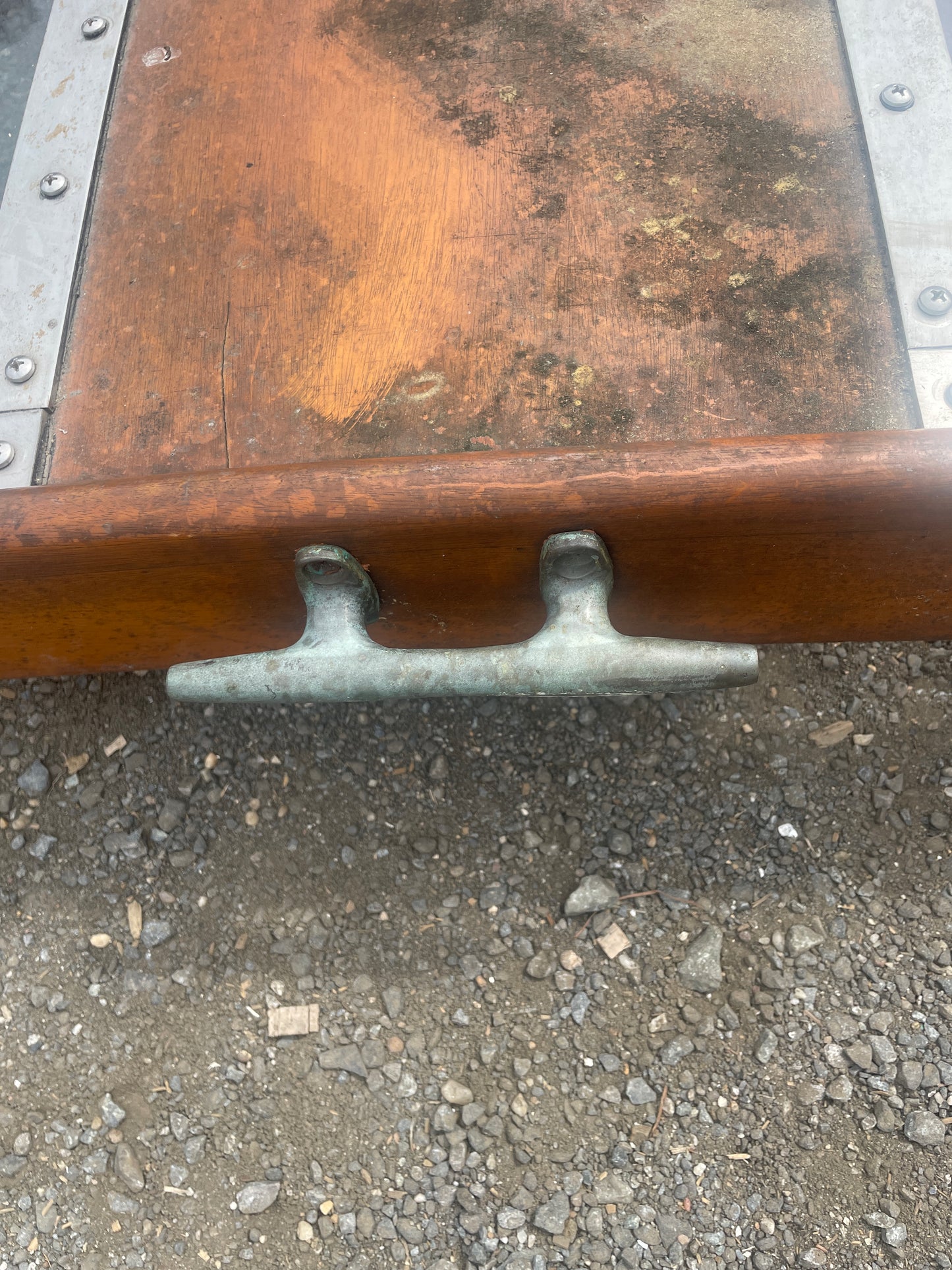 Close-up of a wooden handle with metal fixtures on a textured surface