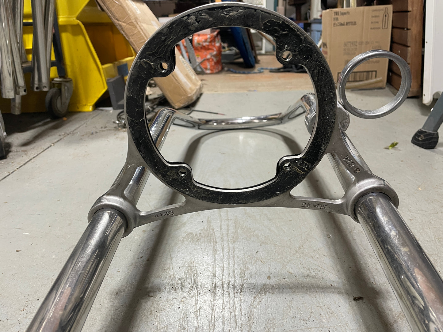 Metal horse bridle bit on a stand in a workshop setting