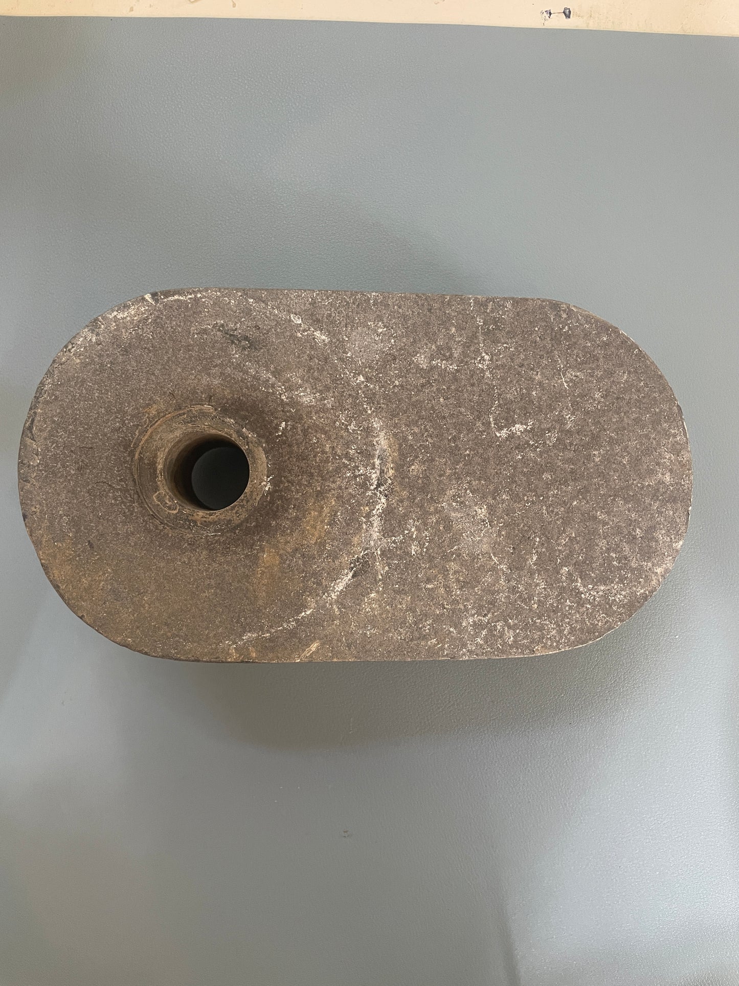 Stone wheel or millstone on a gray background