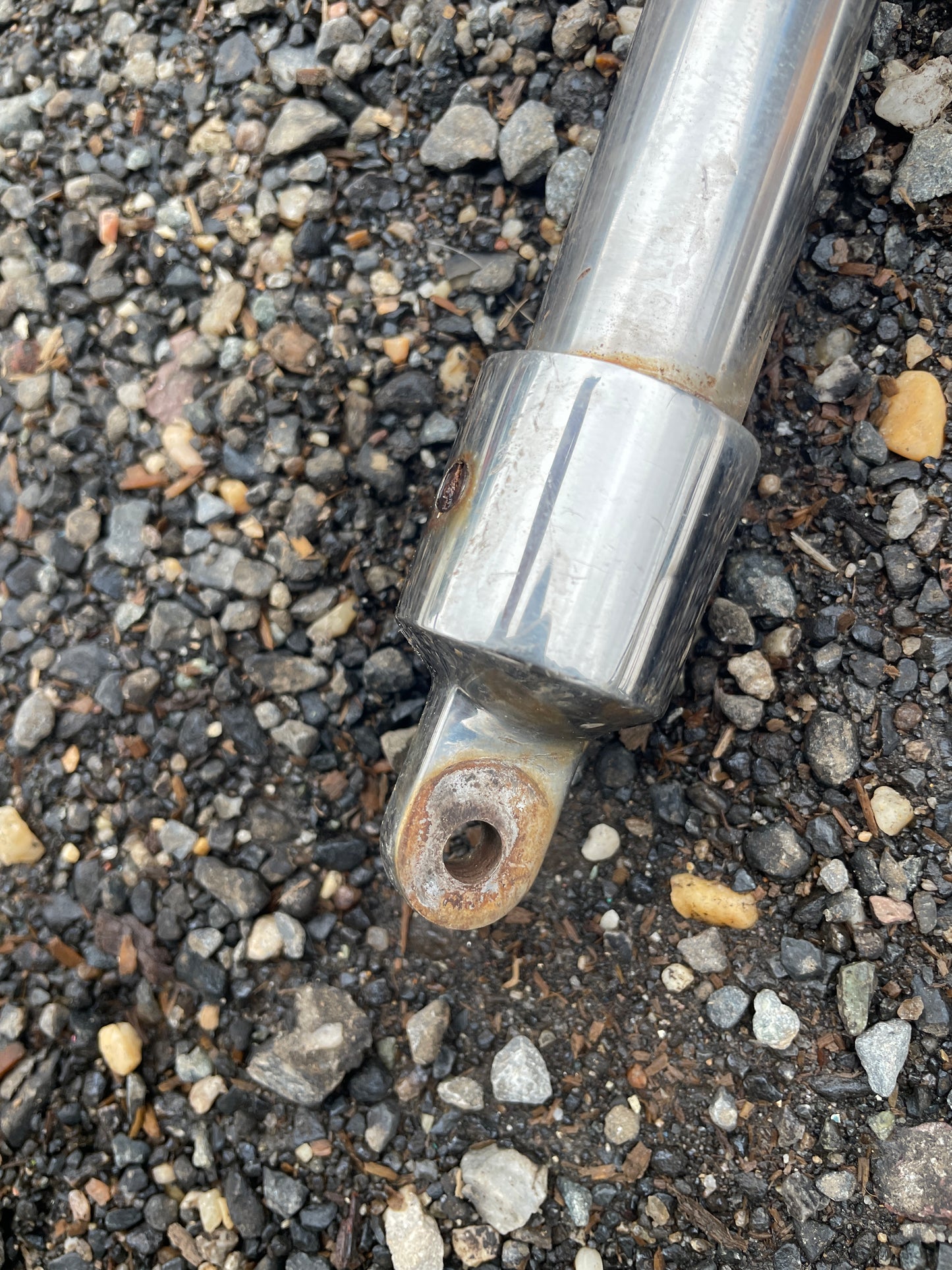 Metallic rod with a threaded end on a gravel surface