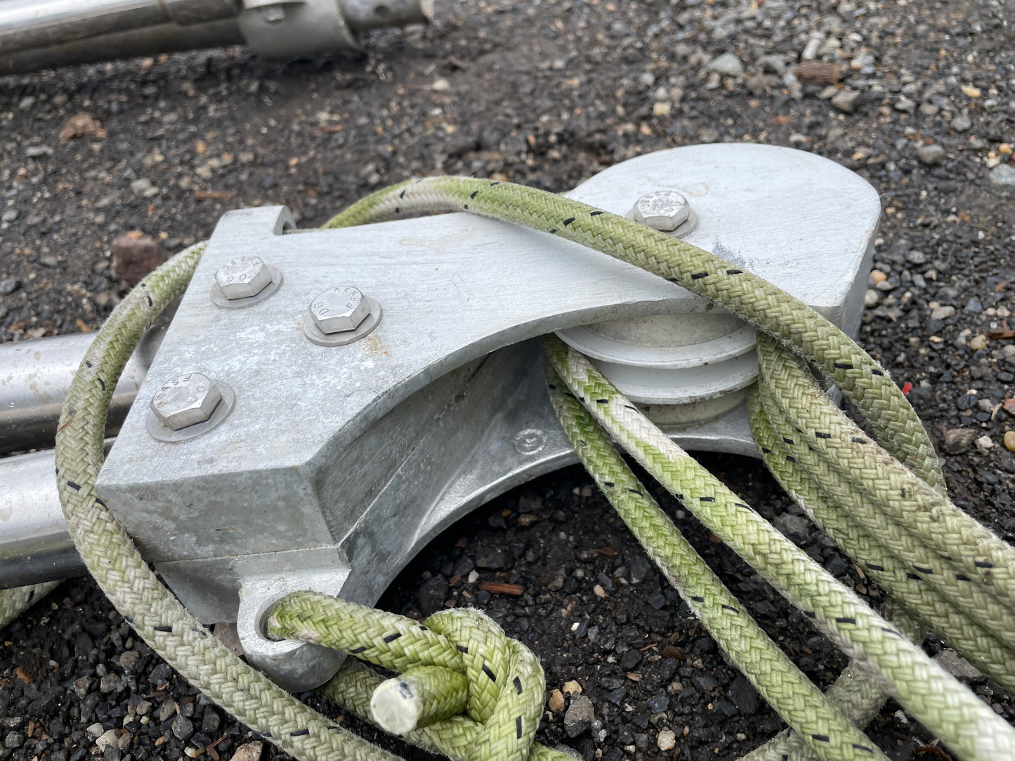 Metal cleat with green rope on a dark surface