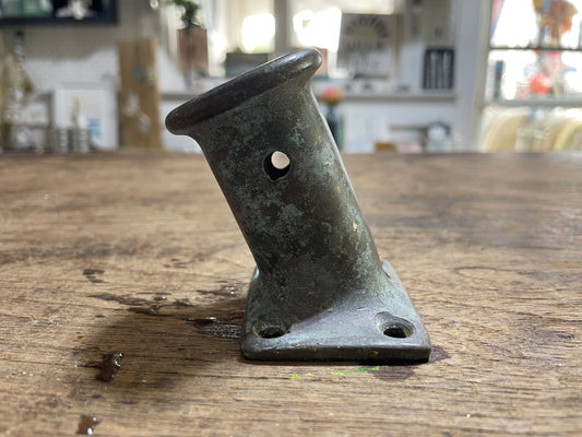 Metal bracket on a wooden surface with a blurred indoor background