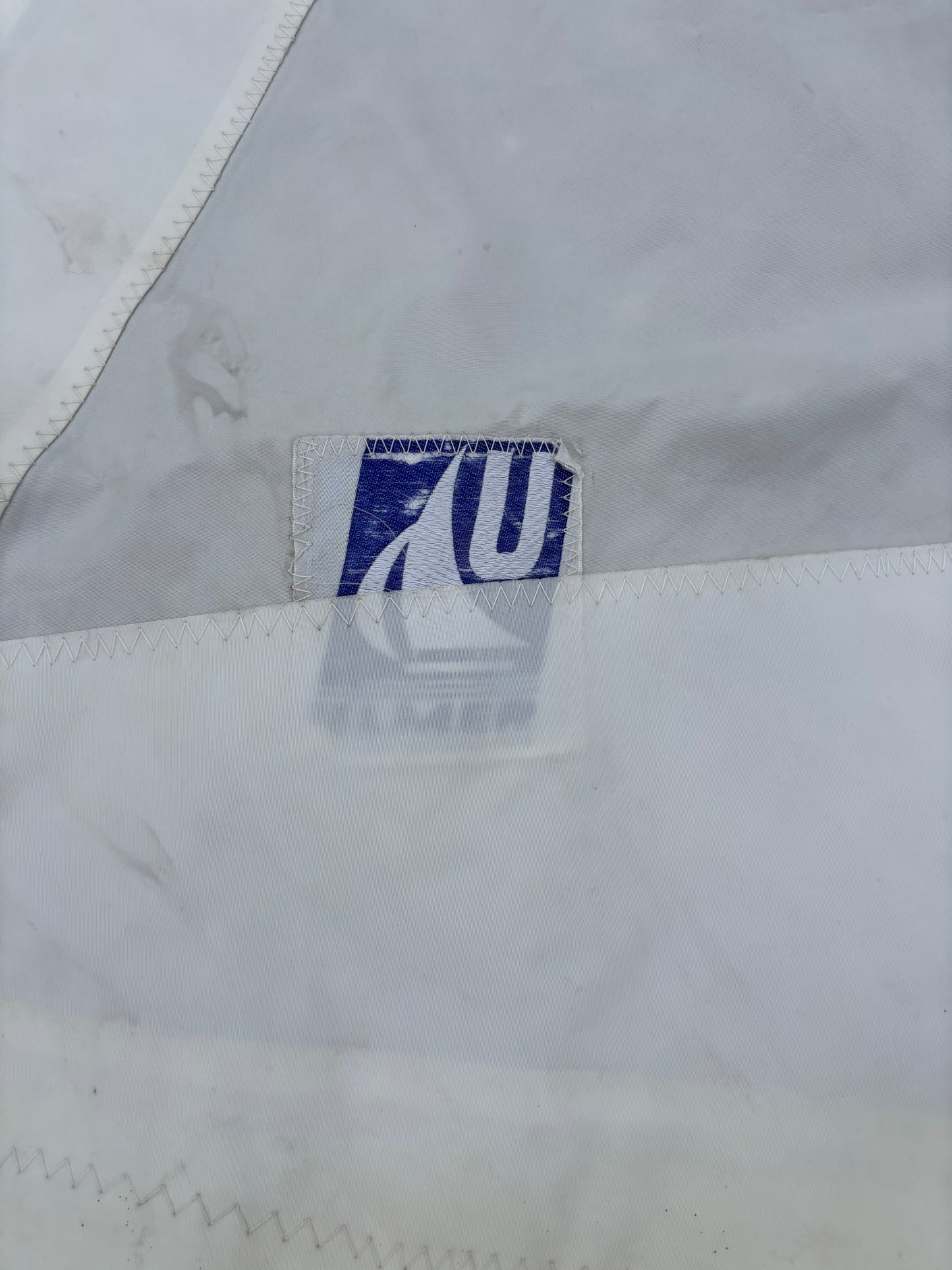Close-up of a brand logo on a white fabric background