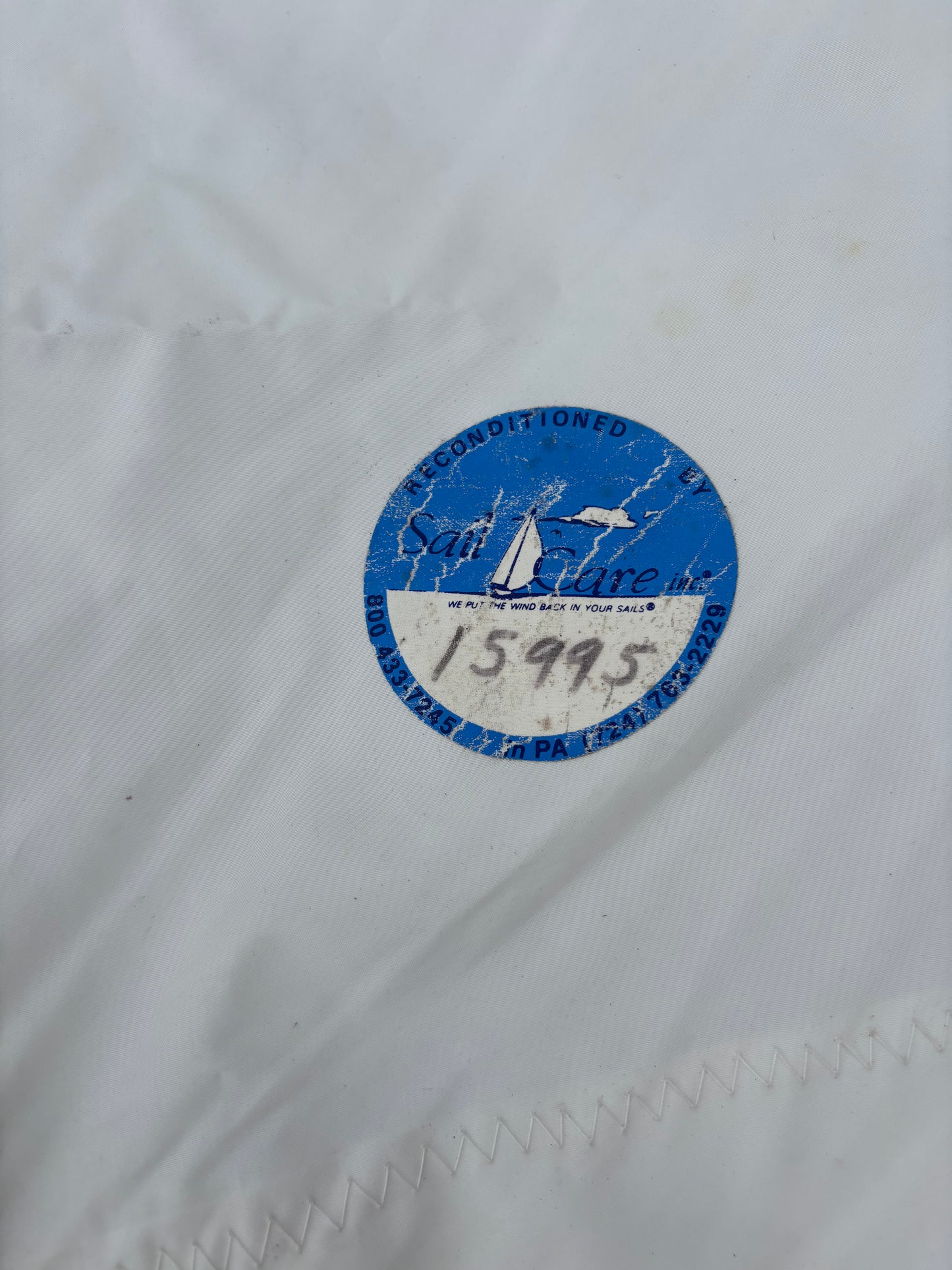 Blue circular label with text on a white fabric background