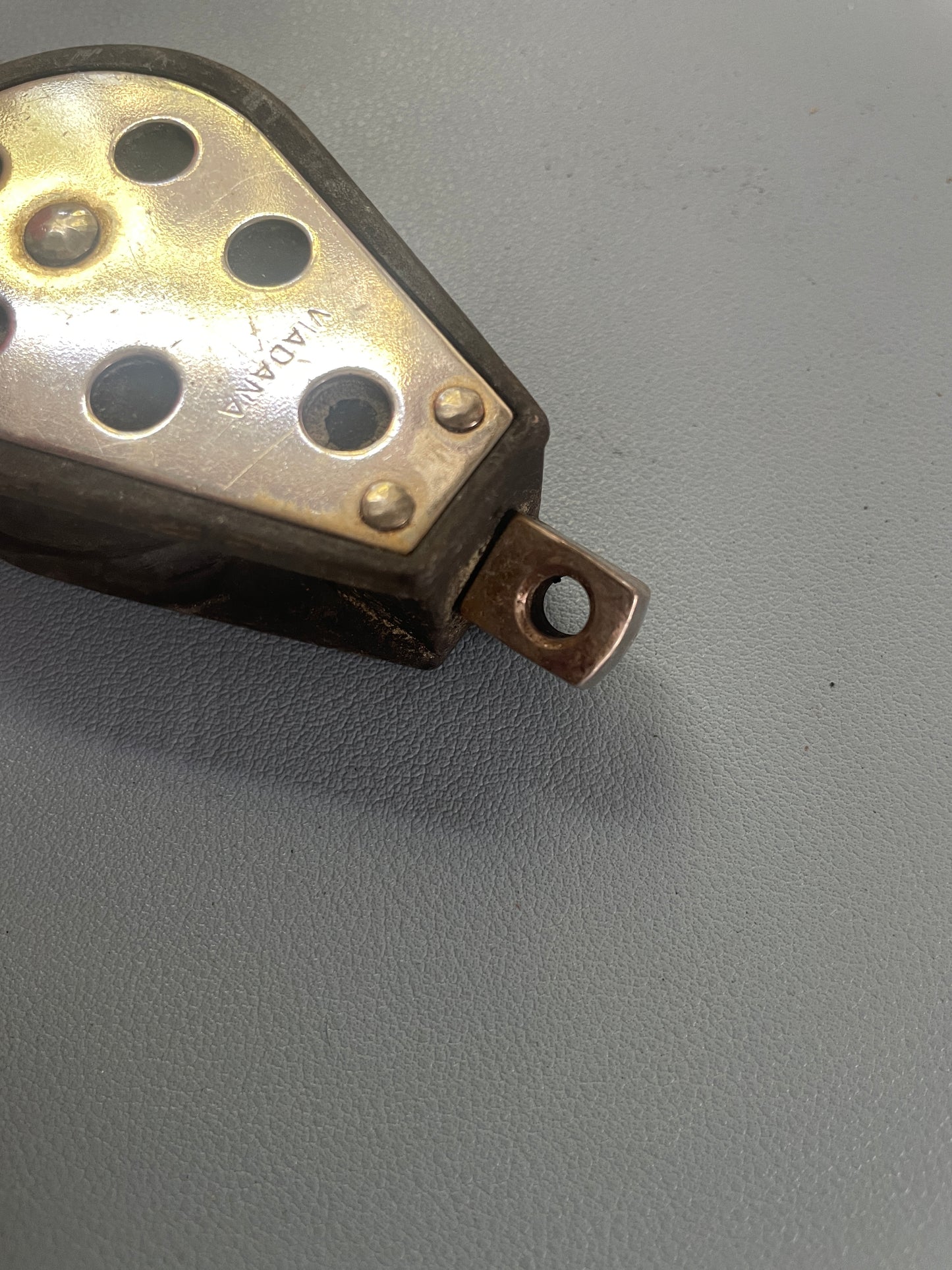 Metallic object with 'Nikola Tesla' branding on a gray background